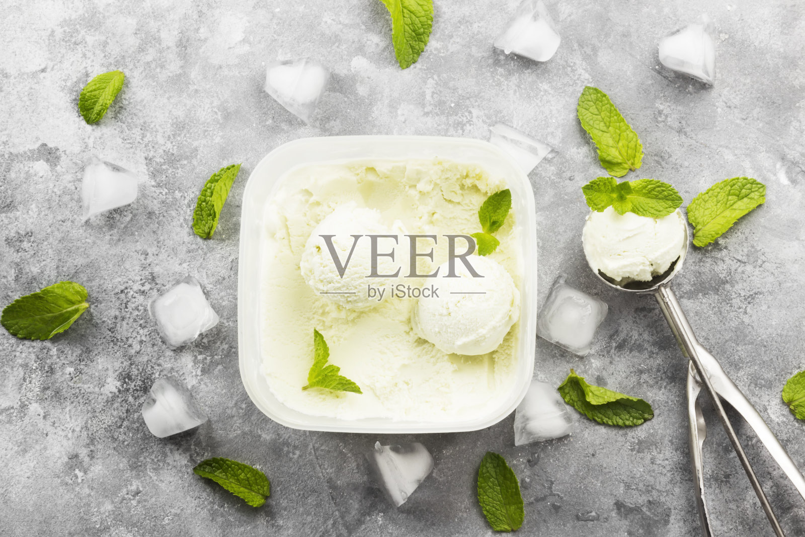 薄荷冰淇淋在碗和勺子冰淇淋在灰色的背景。前视图。食品的背景照片摄影图片