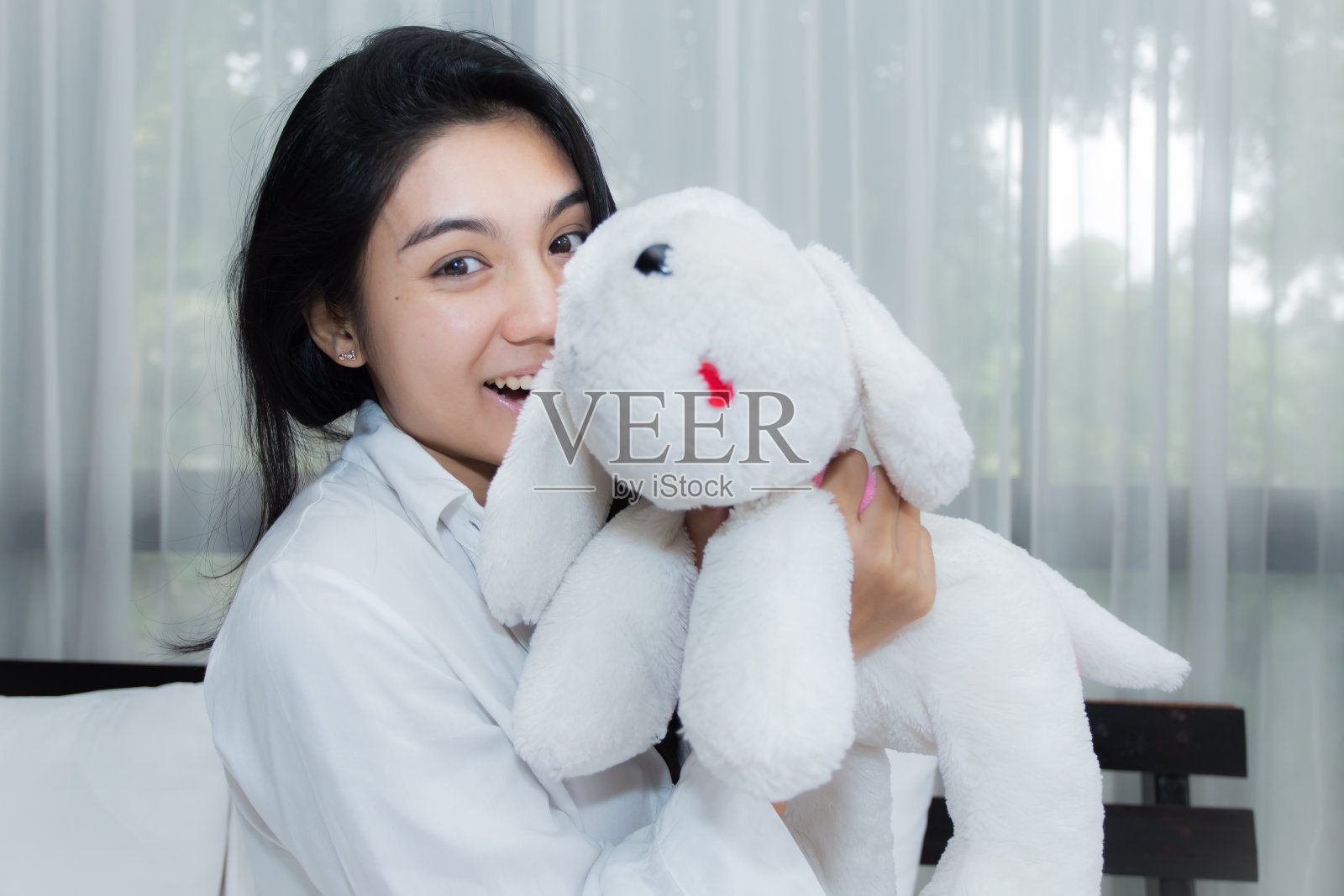 女人在床上玩小狗娃娃照片摄影图片