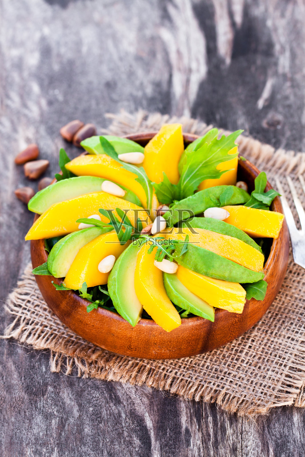 新鲜的蔬菜沙拉，芒果和鳄梨放在木盘子里照片摄影图片