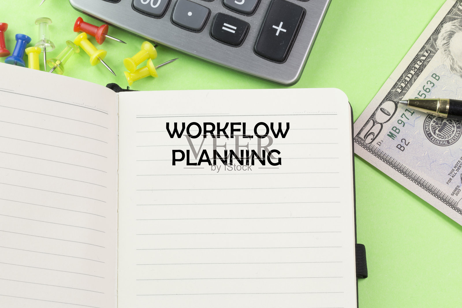 工作流程规划。用书书写文字。绿色背景上的钱、计算器、笔记本和笔。企业财务和规划概念照片摄影图片