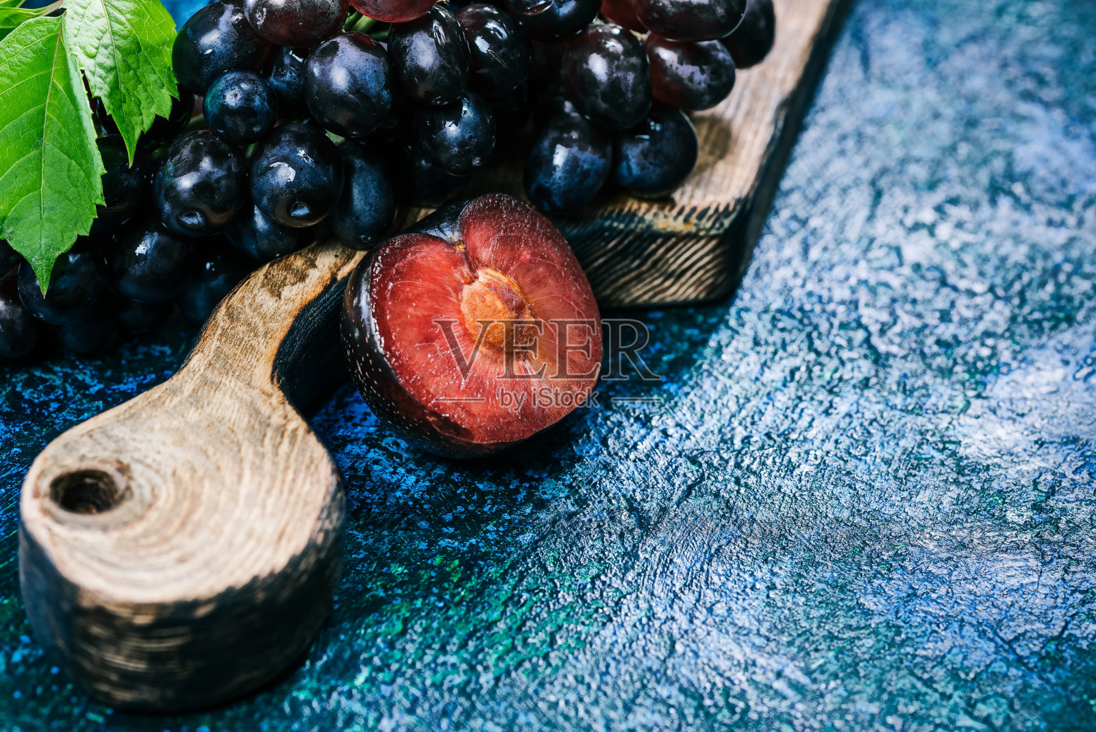 红葡萄和李子放在木板上照片摄影图片