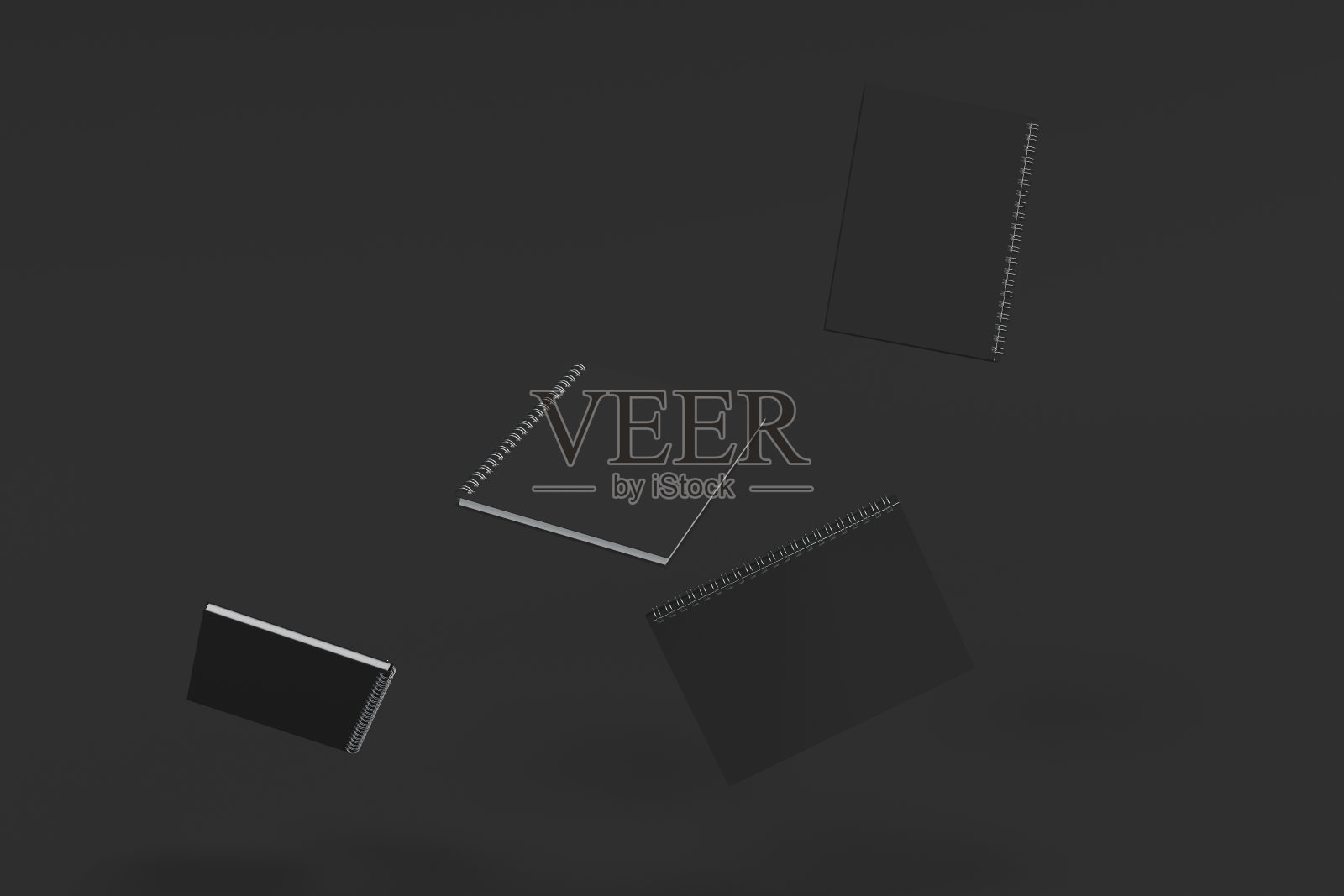 四本黑色背景螺旋装订的笔记本照片摄影图片