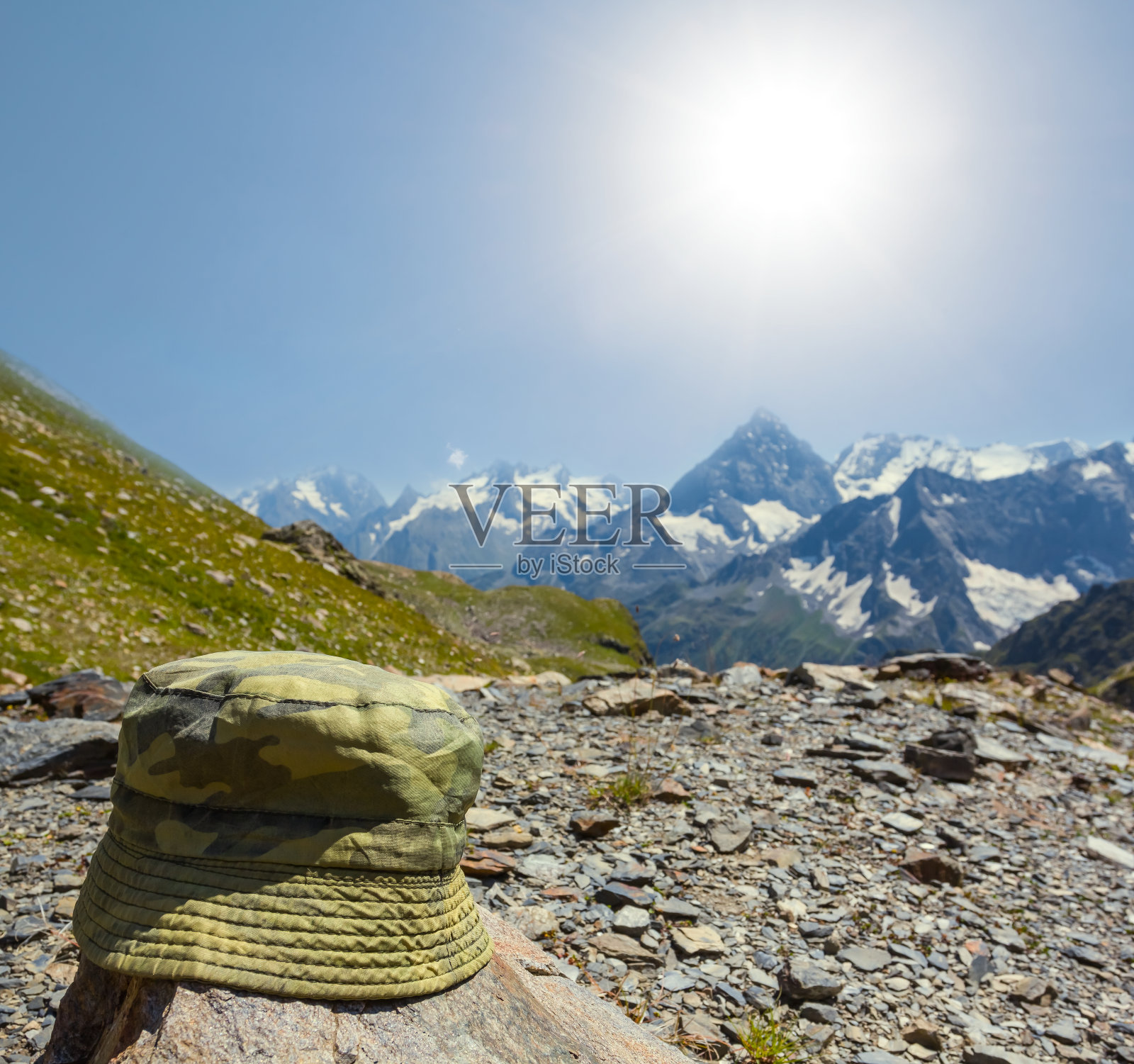 绿色的旅游帽躺在山中的一块石头上照片摄影图片