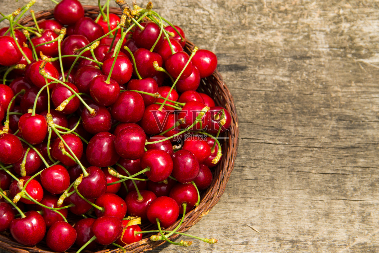 篮子，红色的甜樱桃水果在复古的木桌。夏季水果季节概念照片摄影图片