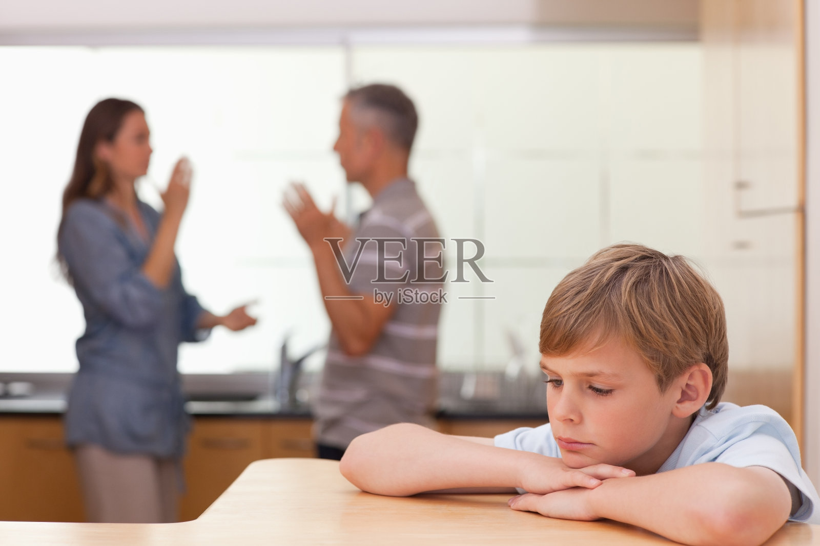 悲伤的小男孩听到他的父母争吵照片摄影图片