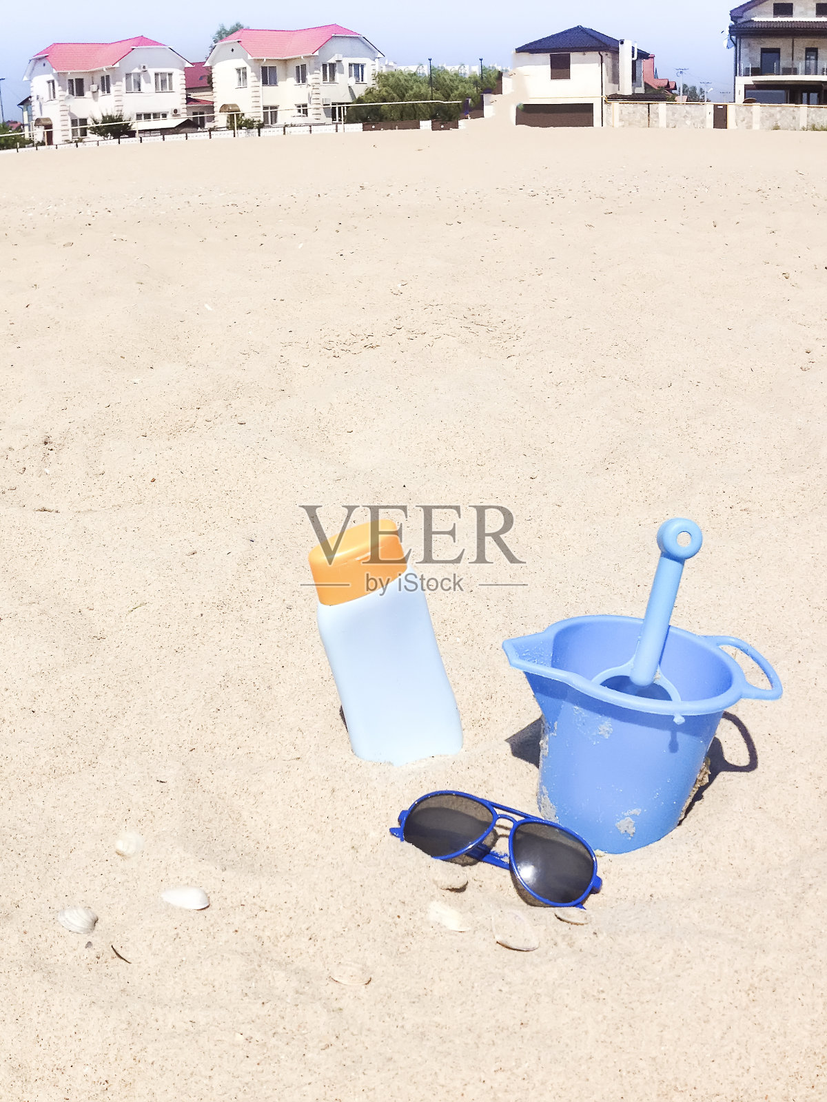 一瓶香油太阳能和太阳镜在沙子上照片摄影图片