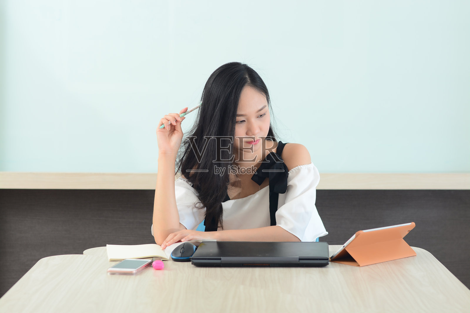 亚洲女性在办公室用笔记本电脑和书籍分析工作照片摄影图片