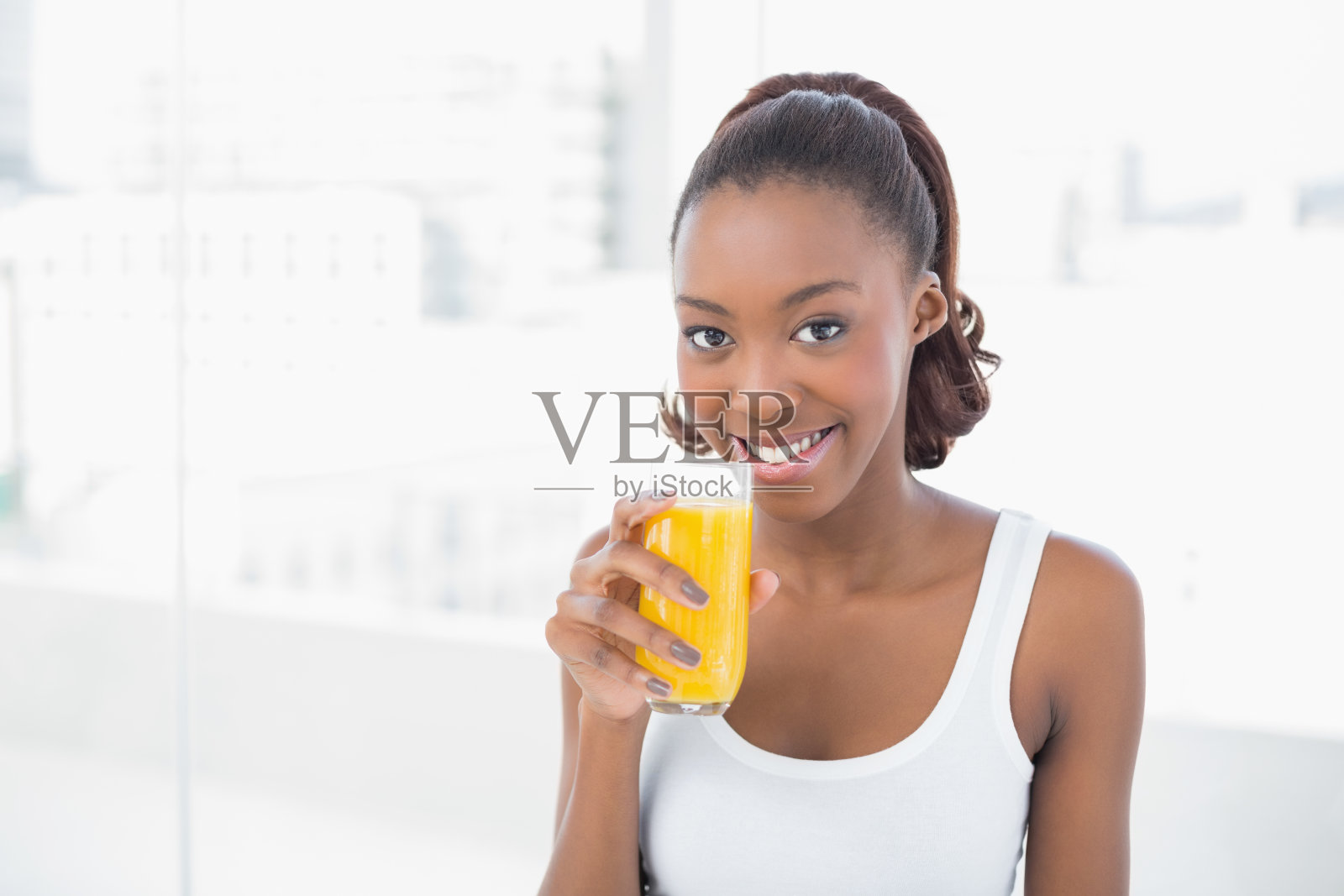 快乐的运动模型拿着一杯橙汁照片摄影图片