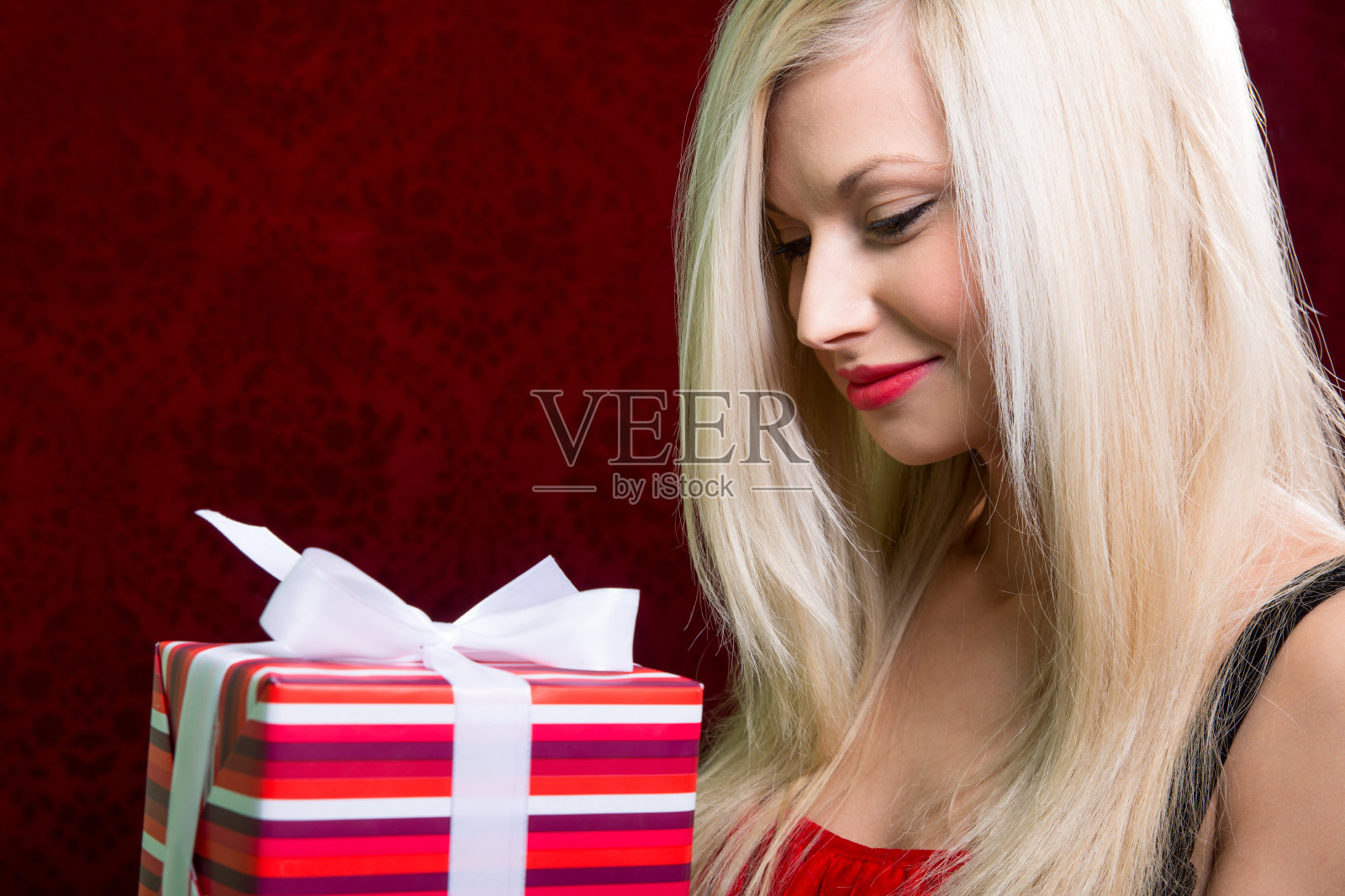 肖像随意年轻快乐金发抱条纹礼盒照片摄影图片