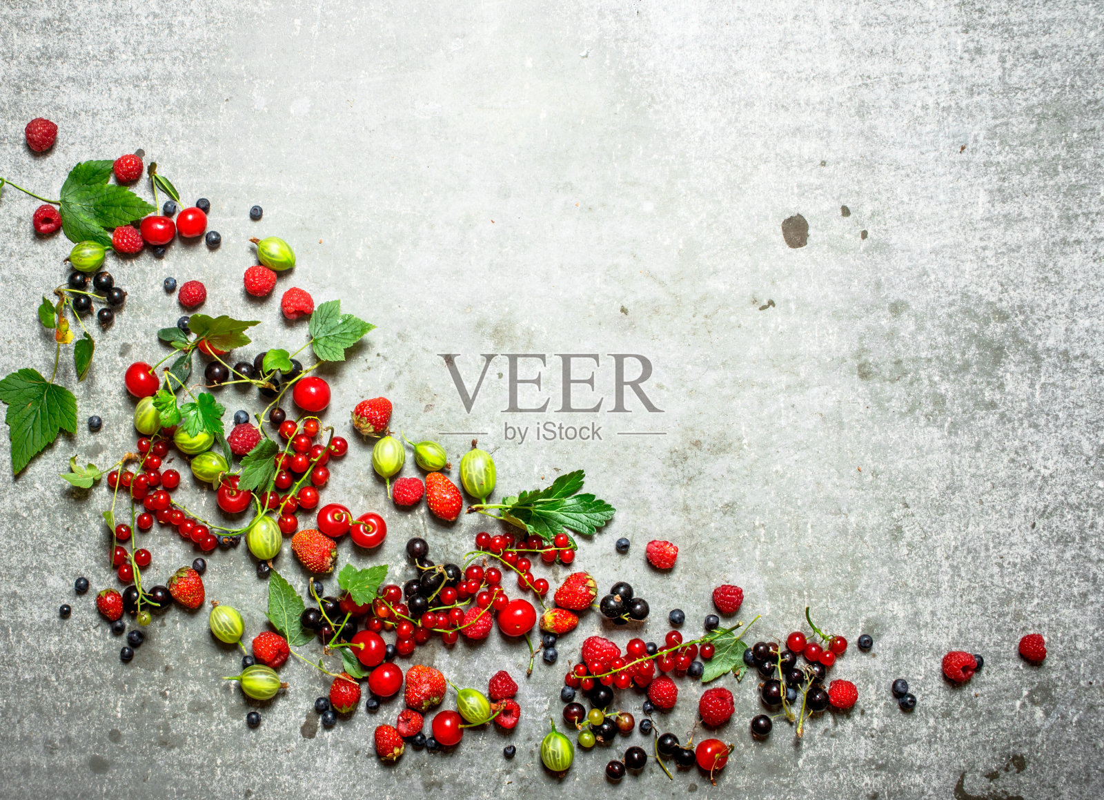 浆果与薄荷叶在石头的背景。照片摄影图片