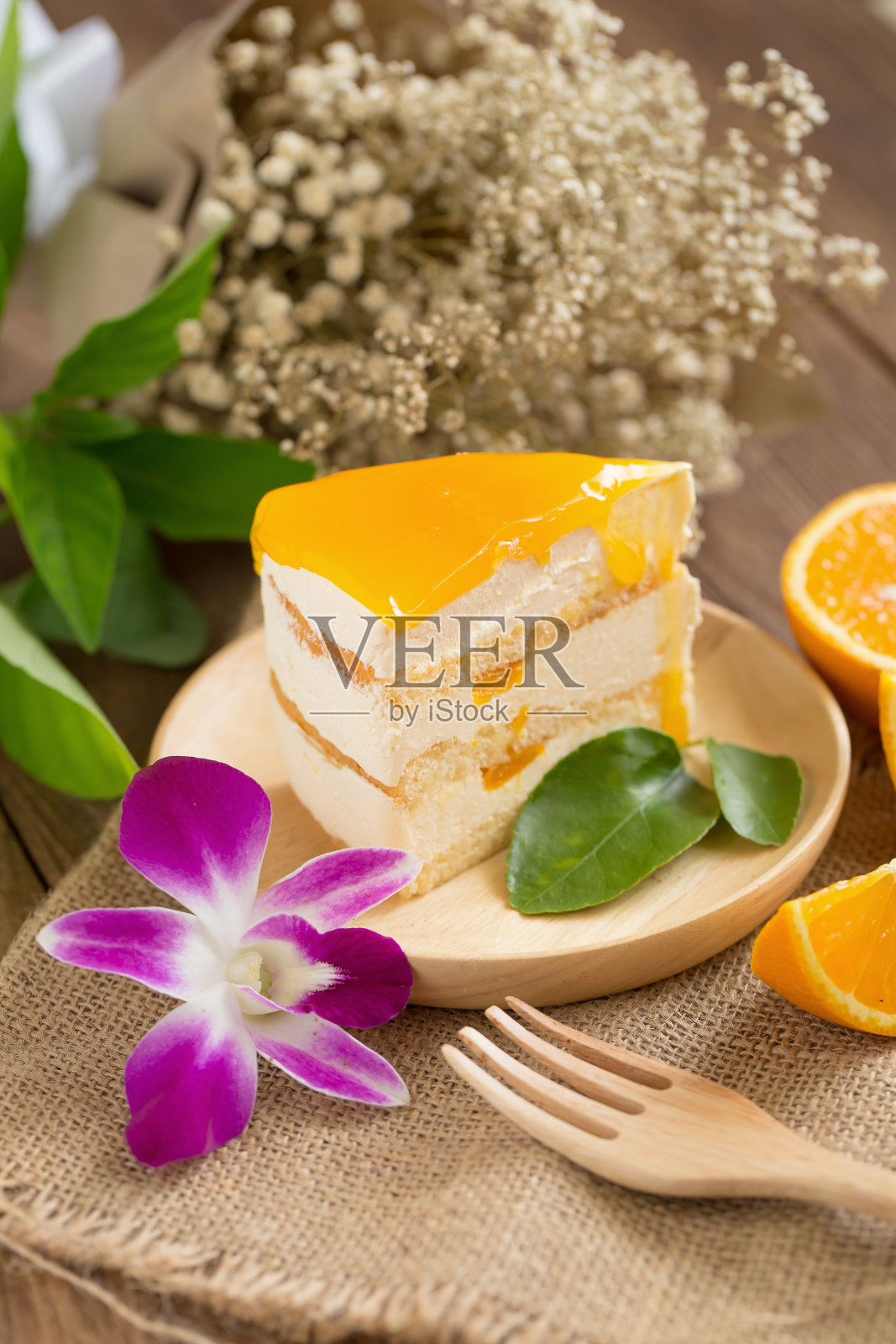 橙子芝士蛋糕，切成薄片，木板上有一片橙子。蛋糕背景概念照片摄影图片