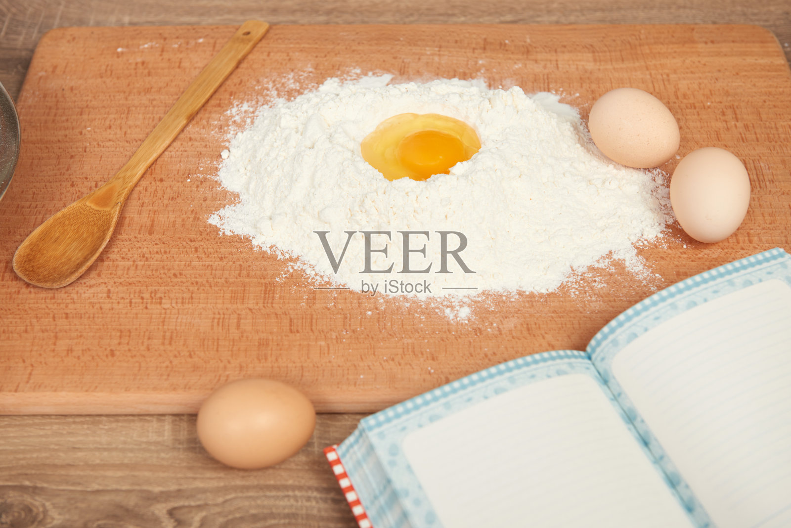 面粉堆和碎鸡蛋特写烘烤在一个木制的背景。生食和厨房用具。照片摄影图片