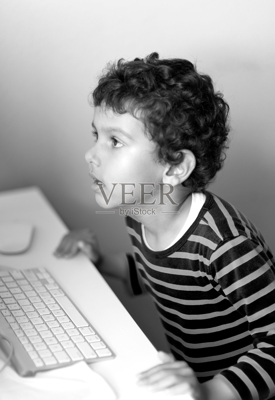 孩子看着屏幕在电脑上工作照片摄影图片