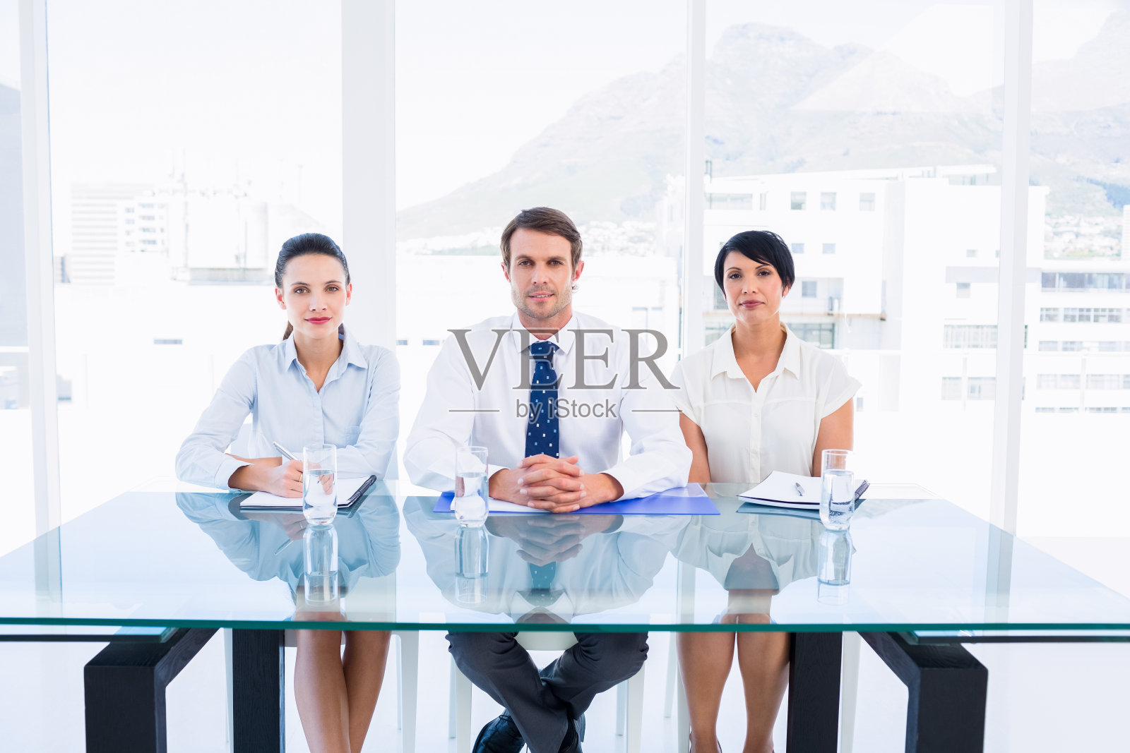 穿着得体的年轻高管坐在办公桌前照片摄影图片