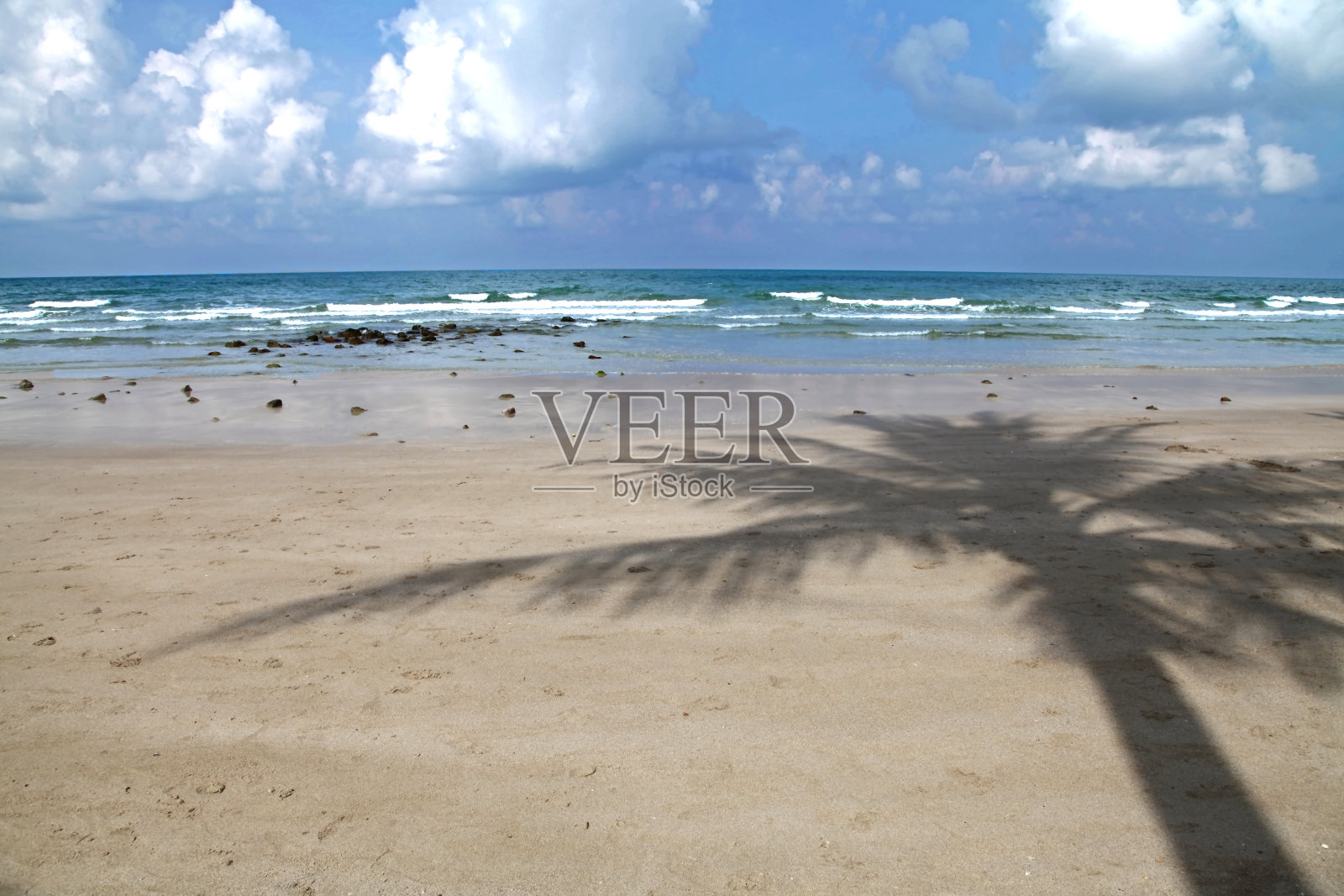 泰国白沙滩上的椰影与蓝天背景照片摄影图片