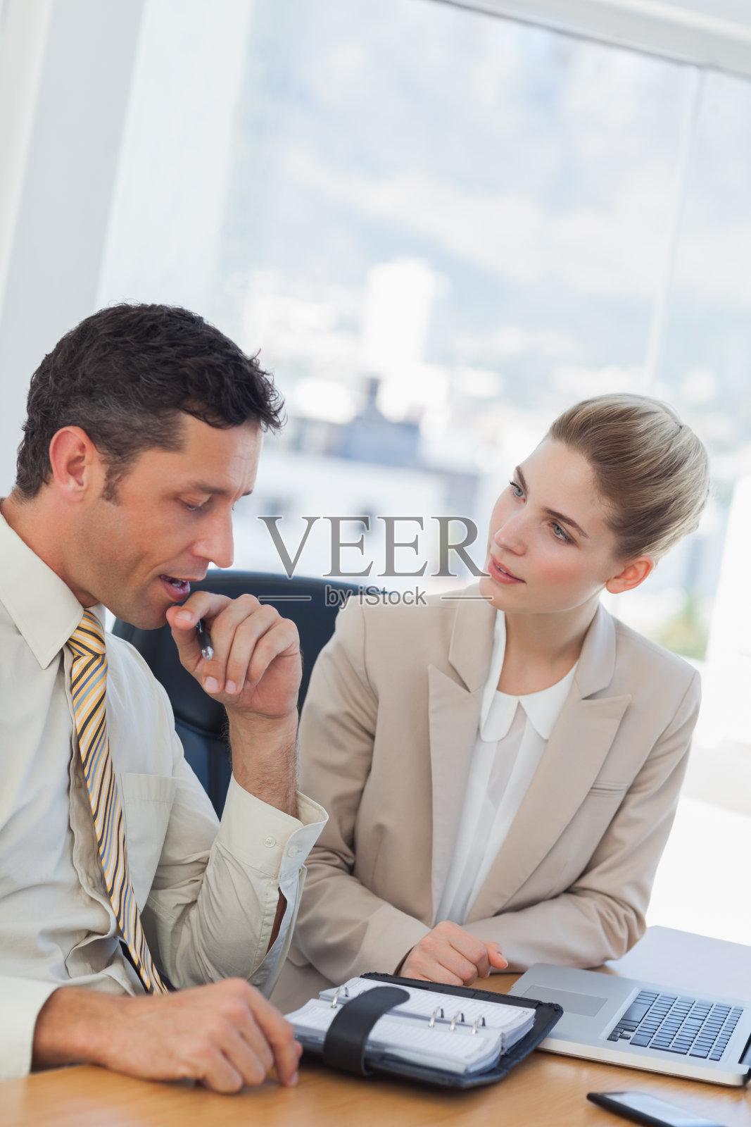 一个商人一边和他的同事聊天一边咨询他的计划照片摄影图片