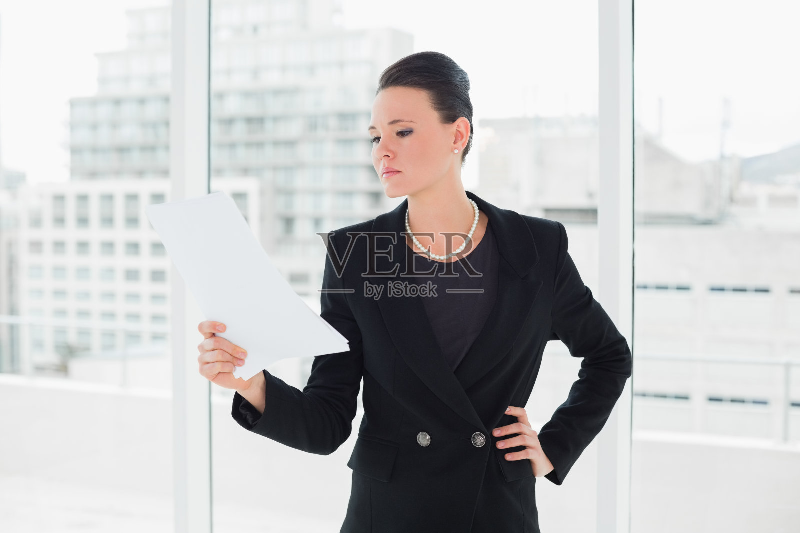 严肃优雅的女人在办公室看文件照片摄影图片