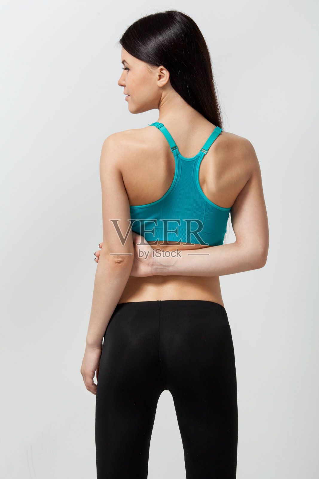 性感的运动女人在一个浅灰色的背景照片摄影图片