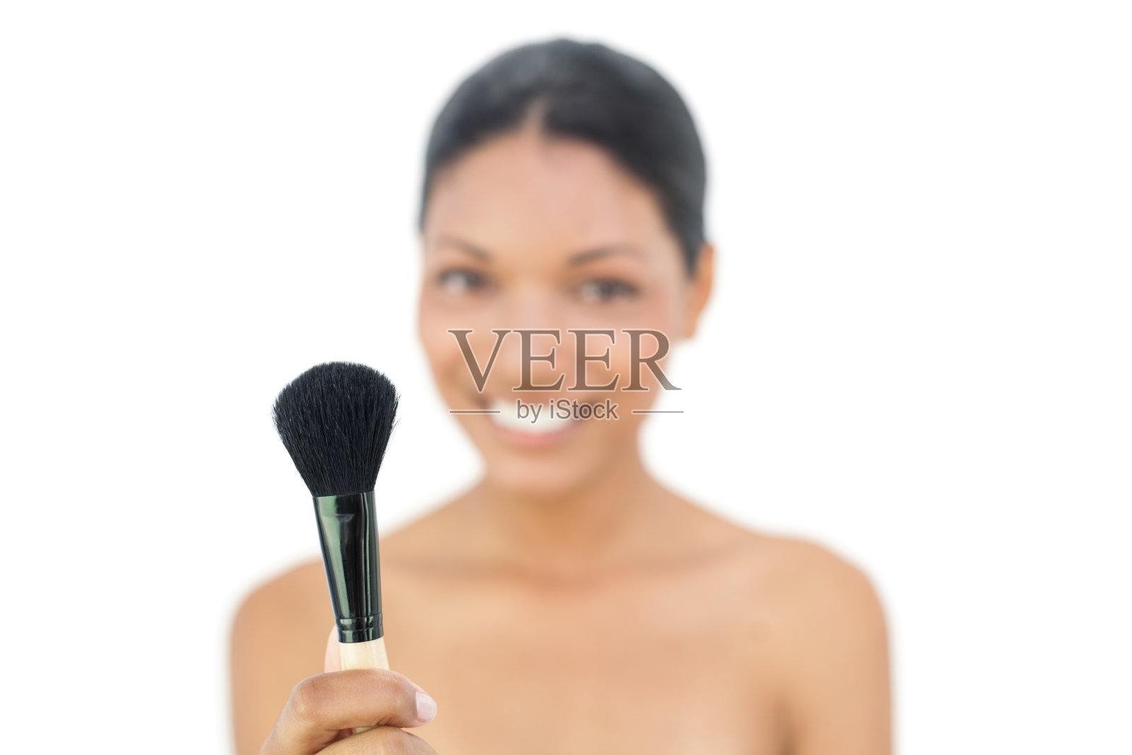 微笑的黑发模特拿着腮红刷照片摄影图片