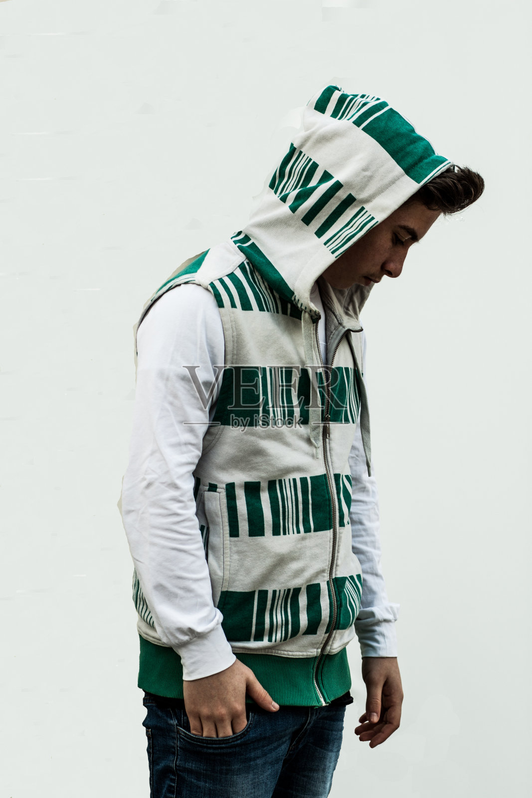 穿着连帽衫的男孩向下看照片摄影图片