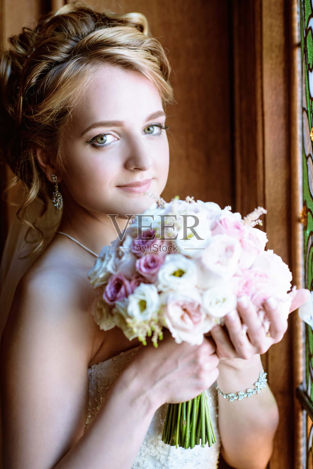 美丽的新娘在室内新娘礼服与花束和蕾丝面纱照片摄影图片