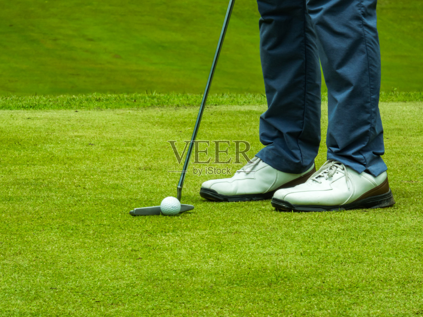 高尔夫球手把高尔夫球打洞给比赛的获胜者和冠军在日落照片摄影图片