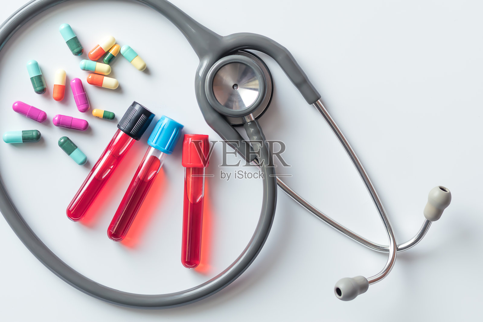 白色背景上有注射器的血液试管和听诊器。照片摄影图片