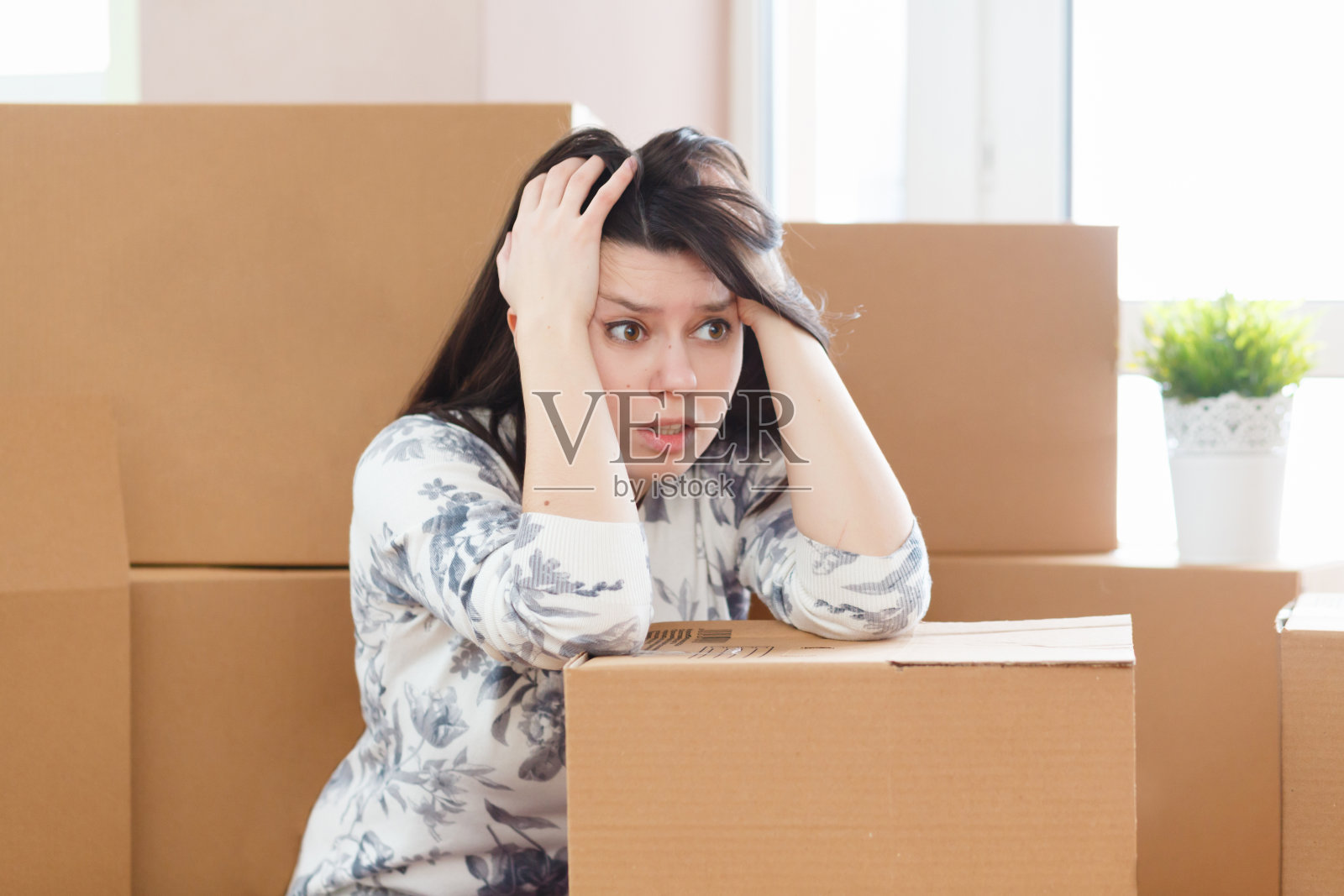 担心和沮丧的年轻女子坐在包装盒子在家里出售照片摄影图片