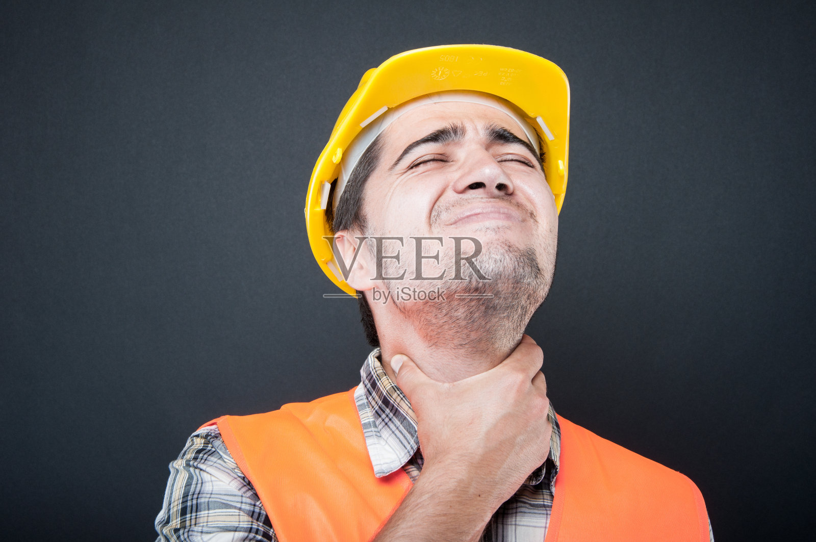 近距离拍摄的构造师戴着设备扼住喉咙，好像很疼照片摄影图片