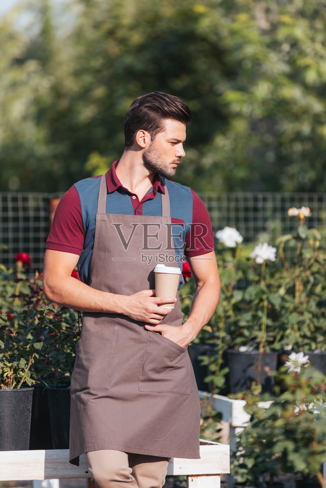 肖像沉思的园丁与咖啡去看，而站在花园照片摄影图片