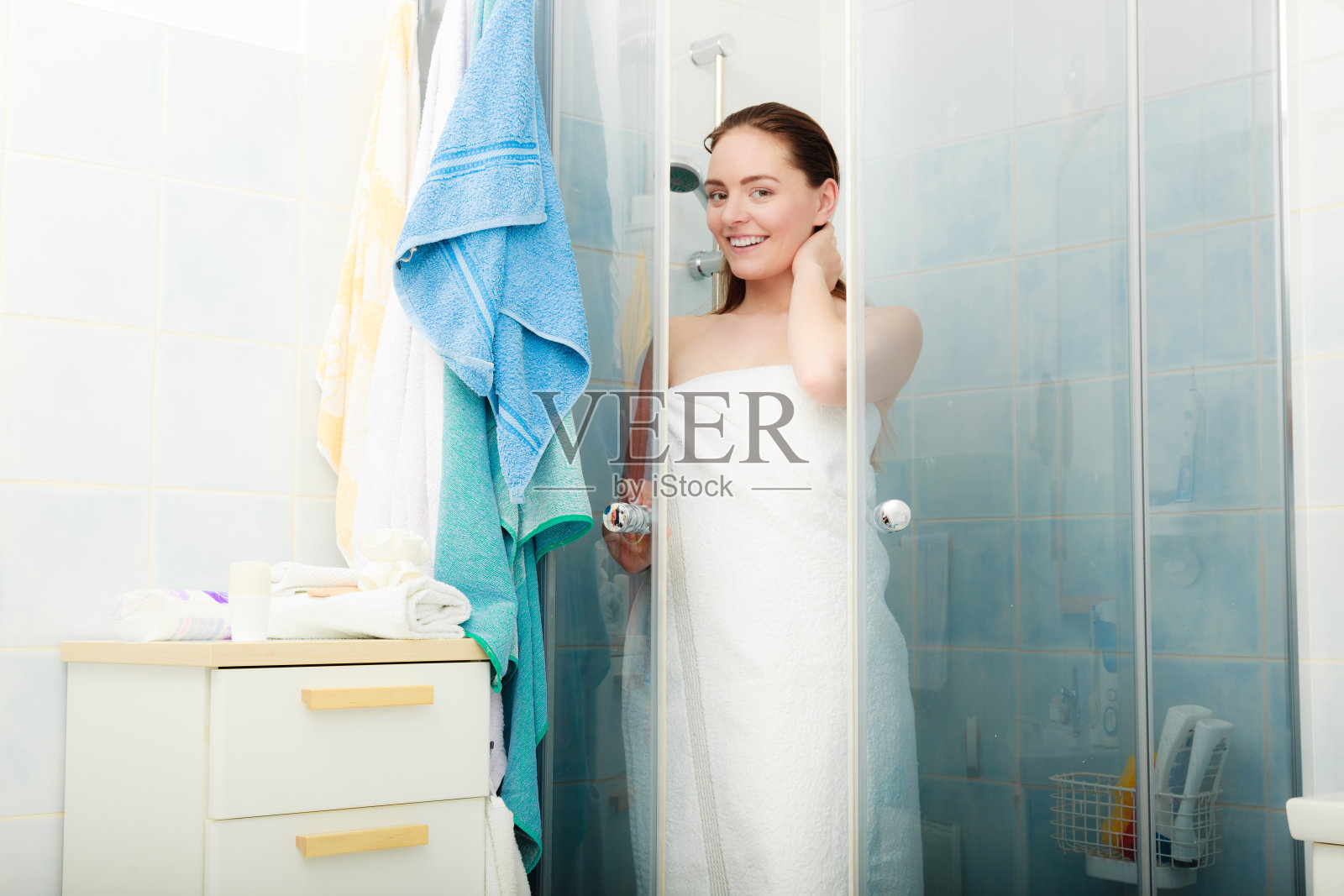 在淋浴间里洗澡的女人。照片摄影图片