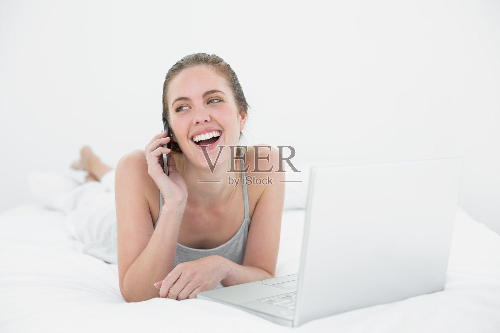 用手机和笔记本电脑的开朗随意的女人照片摄影图片