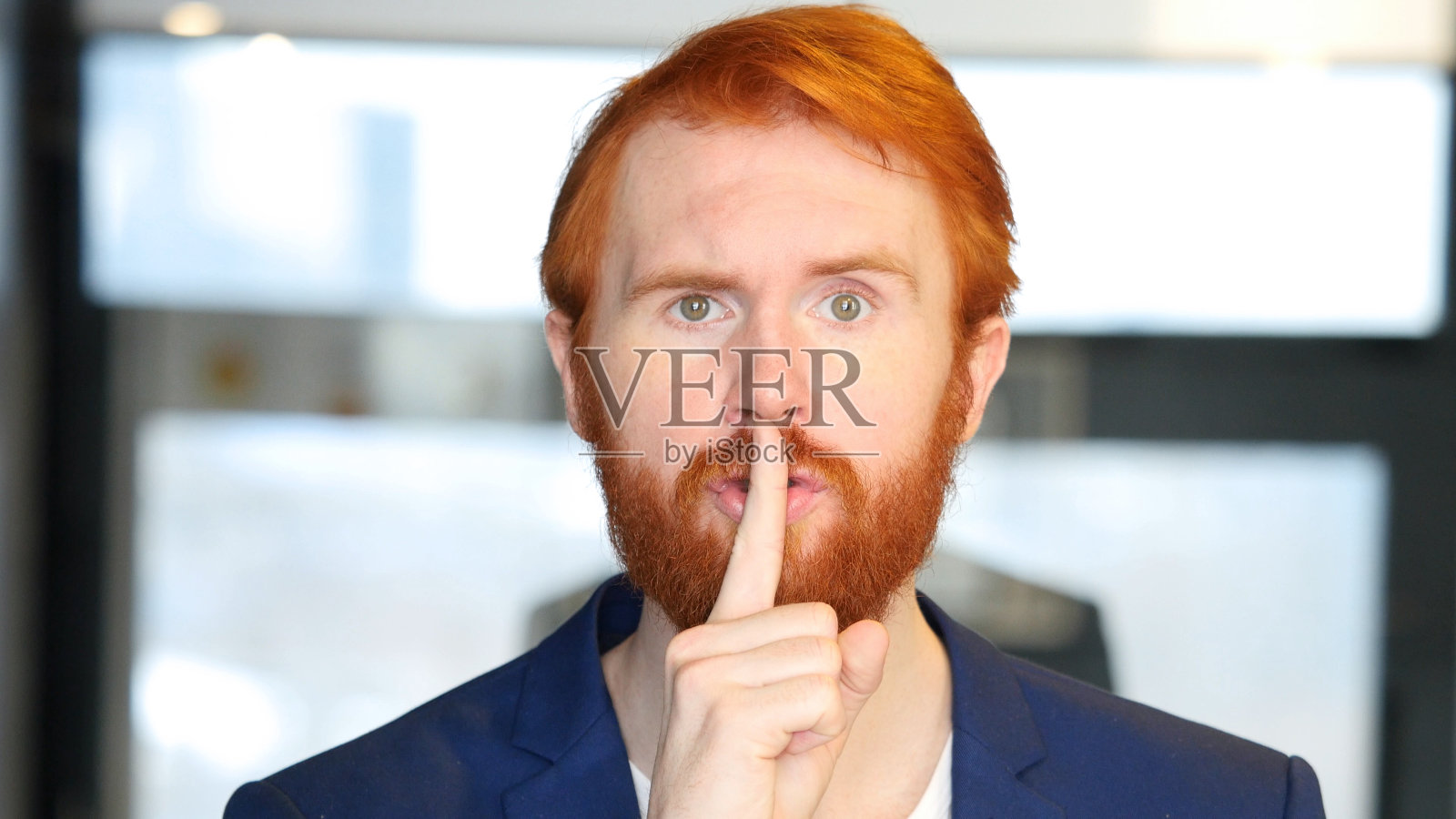 商人沉默，手指放在嘴唇上照片摄影图片