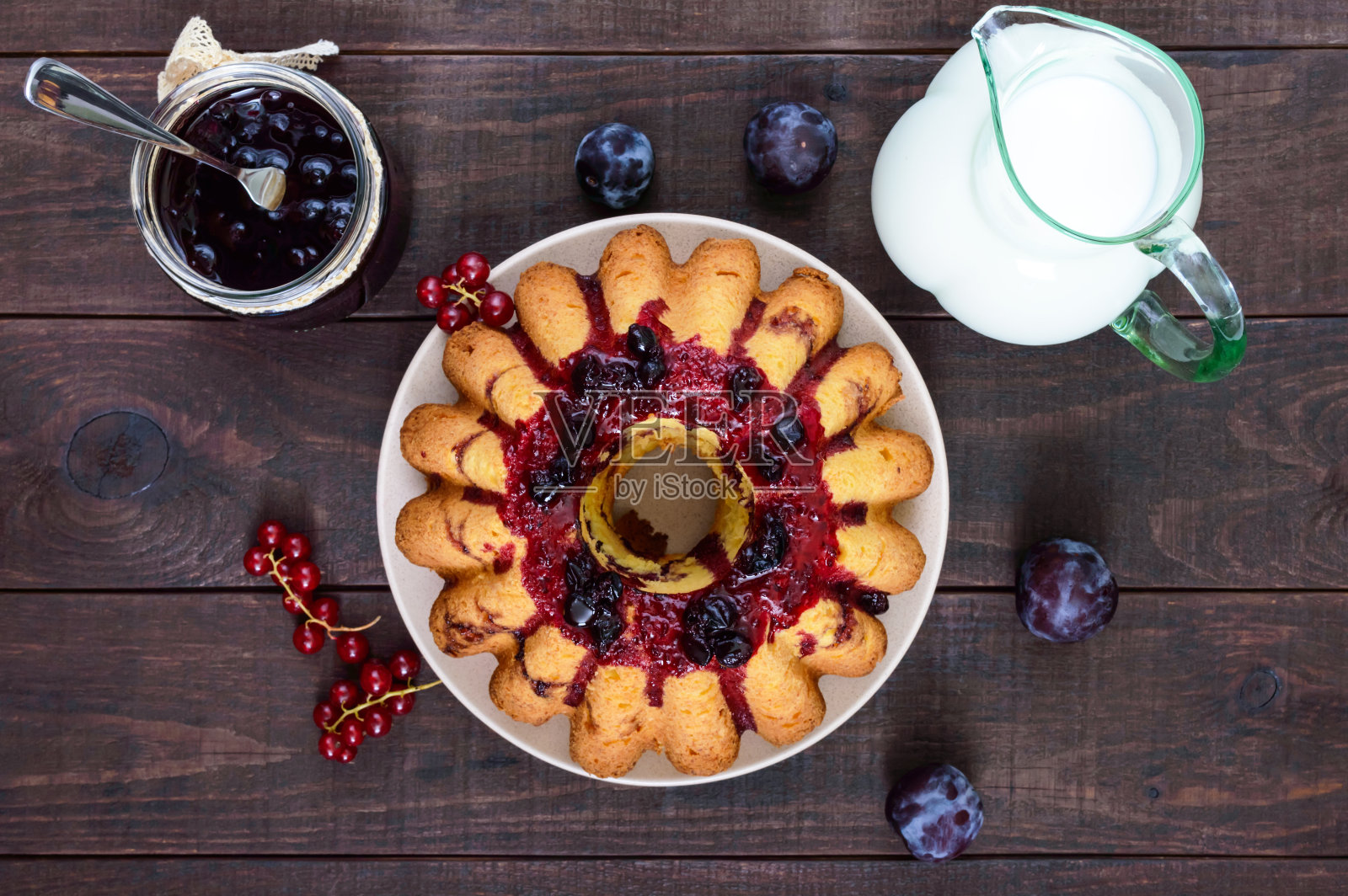 黑色的木桌上放着新鲜出炉的夏日浆果蛋糕。照片摄影图片