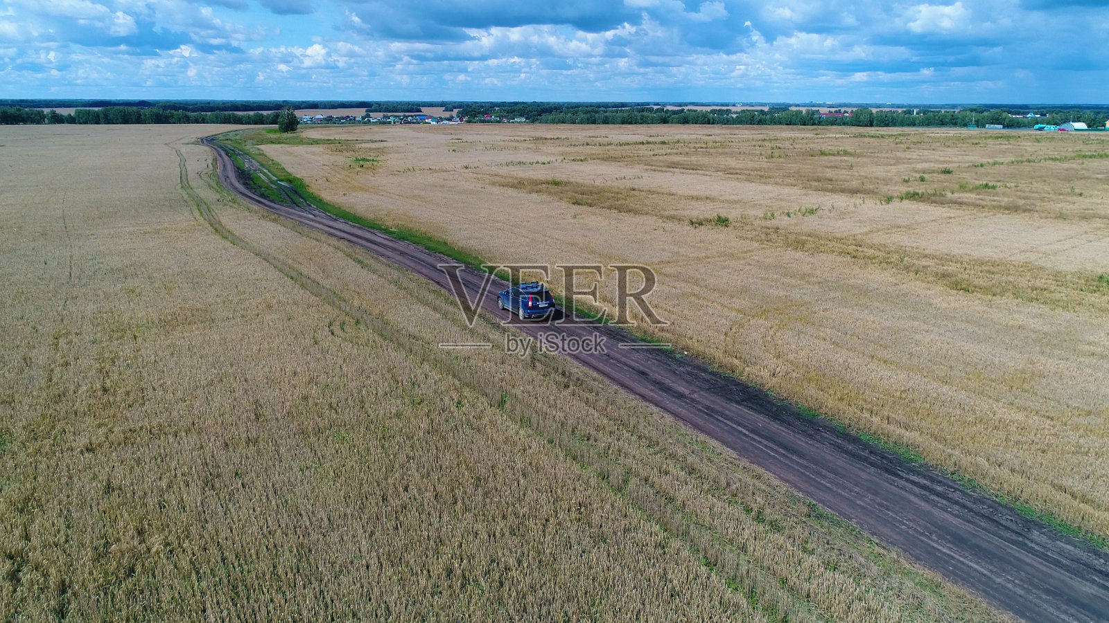 汽车沿着麦田行驶。从高处俯瞰美丽的风景。从高处拍照照片摄影图片