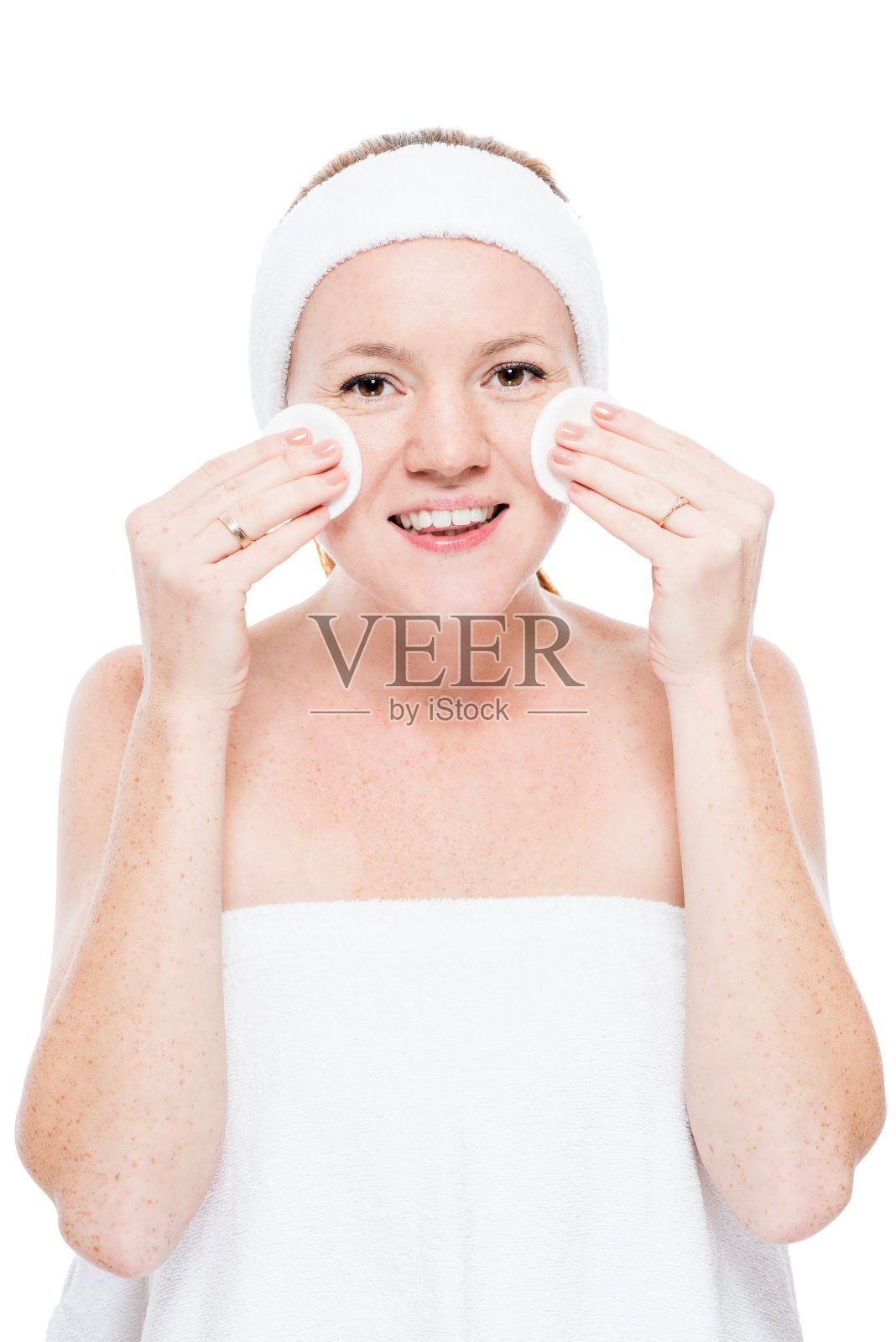 在白色的背景下，沐浴后用棉垫用毛巾擦拭皮肤照片摄影图片