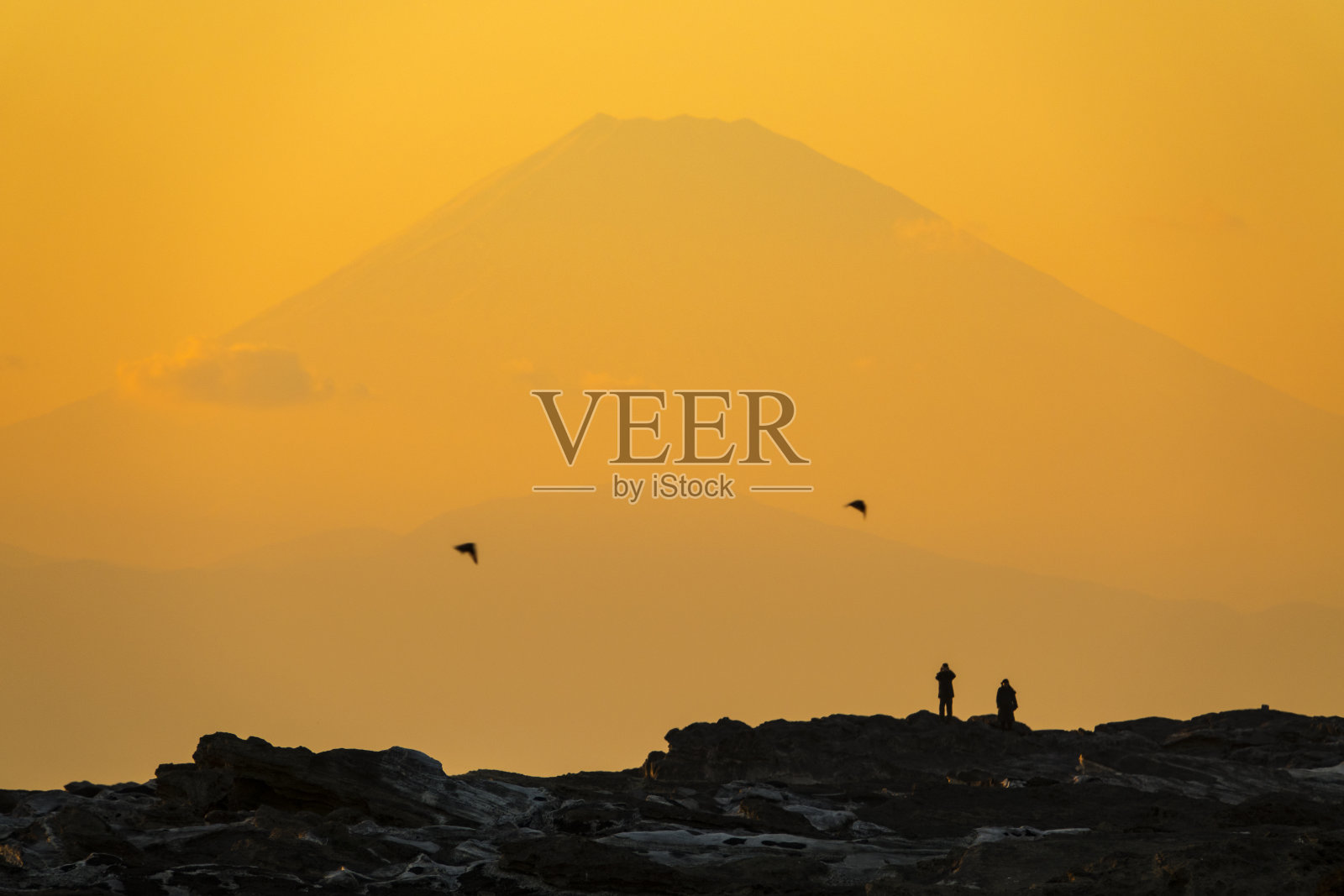 黄昏时分富士山上人们的剪影照片摄影图片