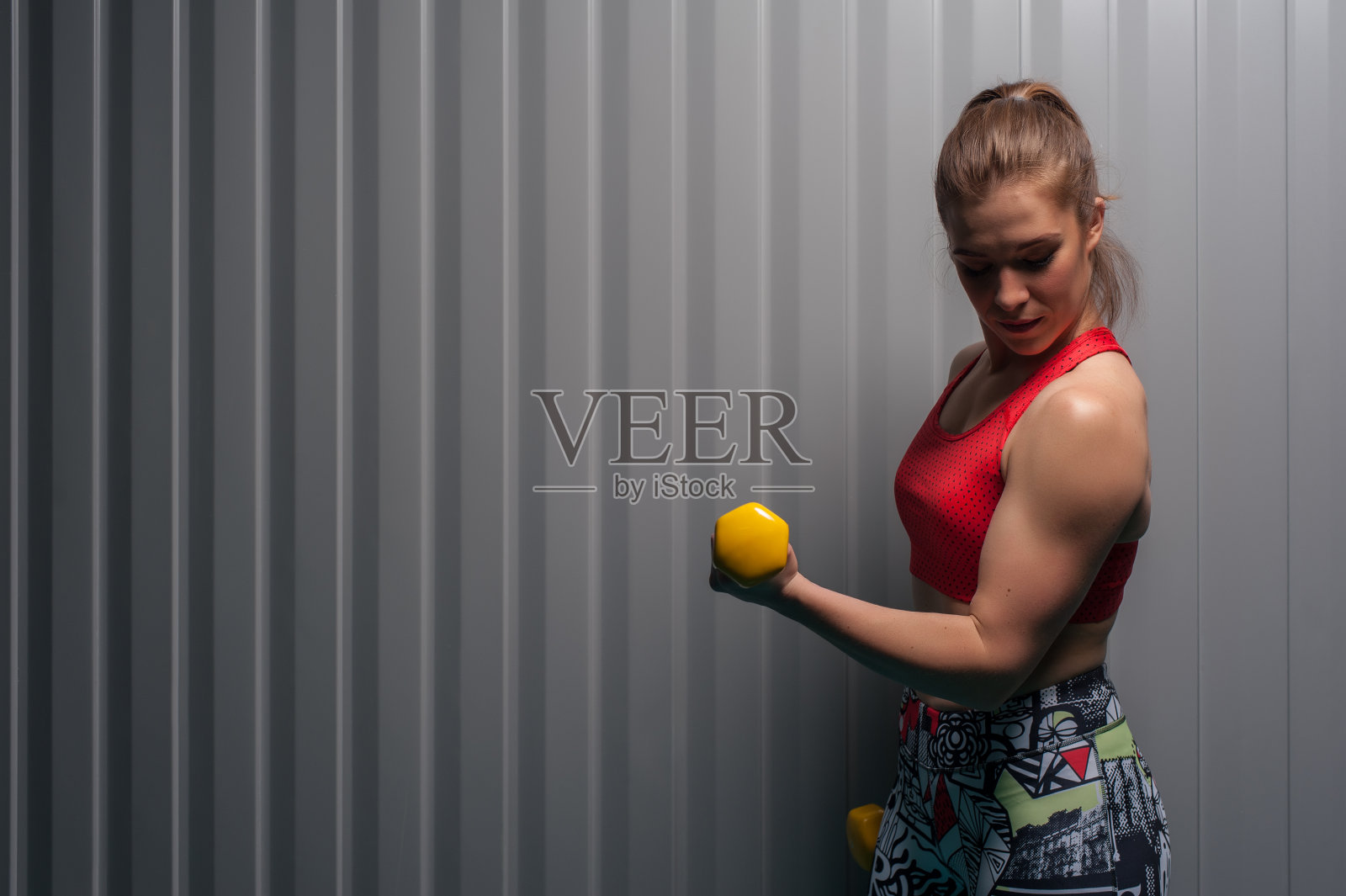 女性成年人做负重二头肌锻炼照片摄影图片