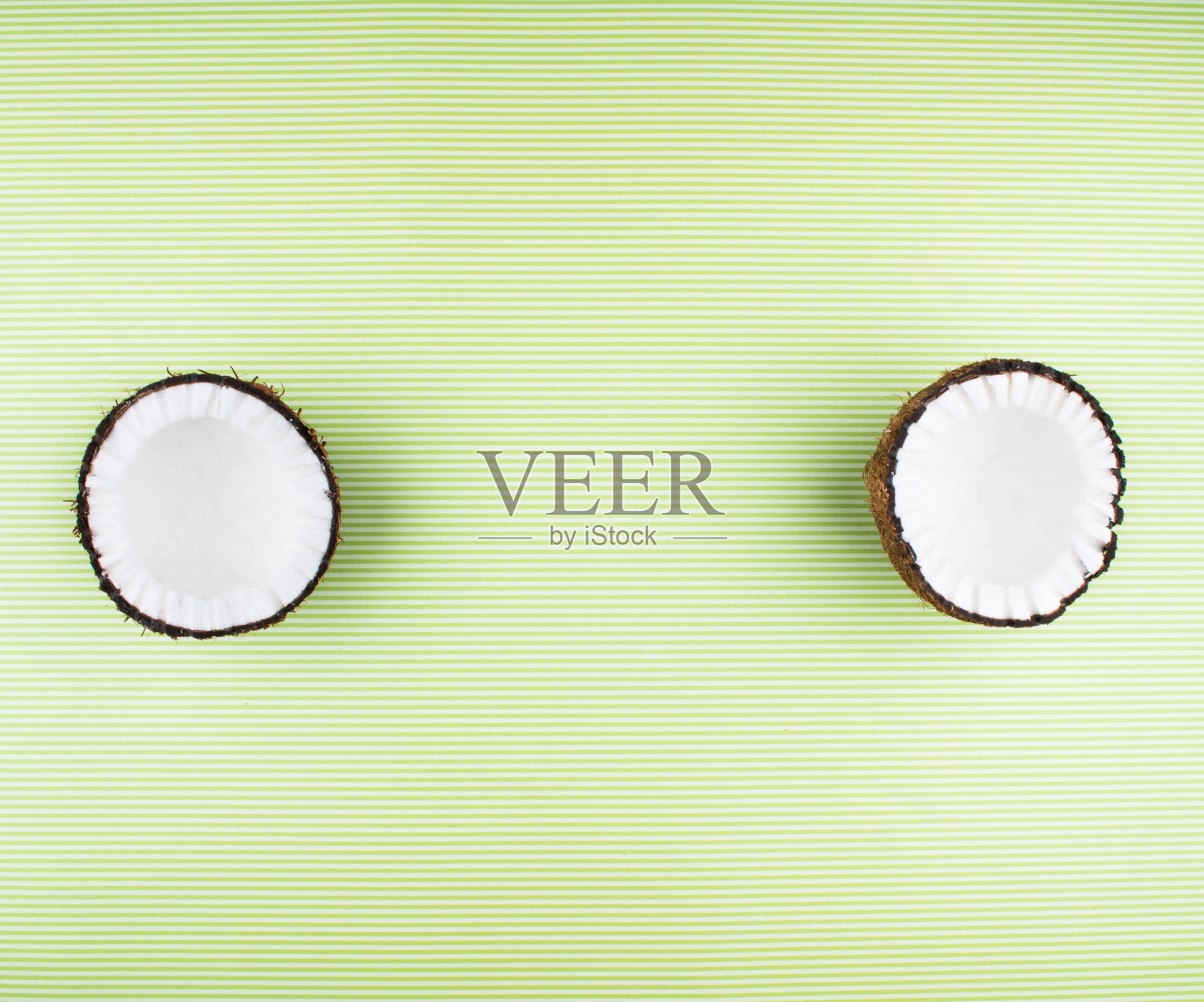 绿色背景上的椰子果实。照片摄影图片