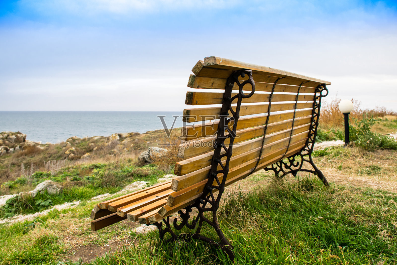 大海前面的木凳。美丽的长椅，背景是大海照片摄影图片