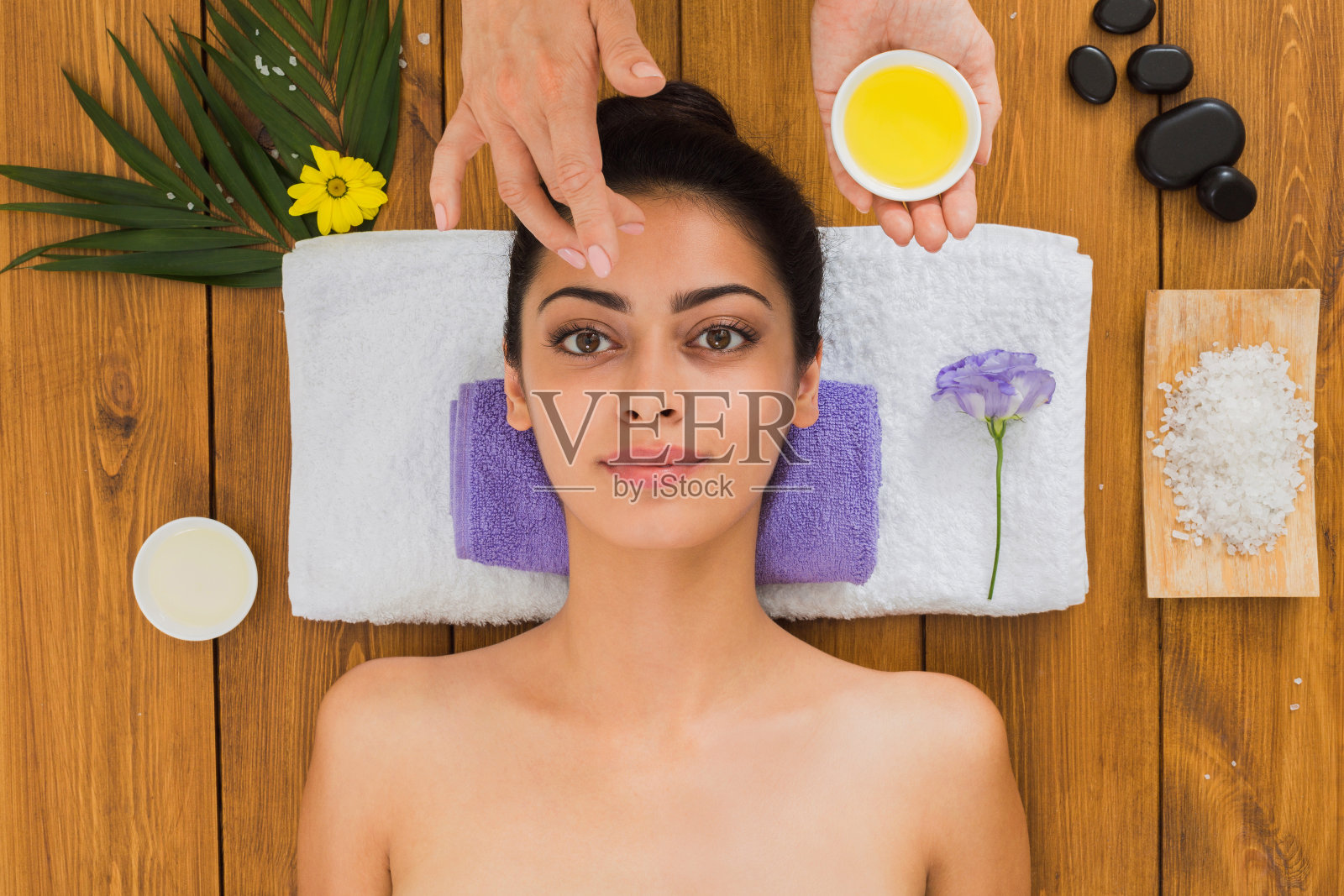 女性按摩师在水疗健康中心做面部提拉按摩照片摄影图片