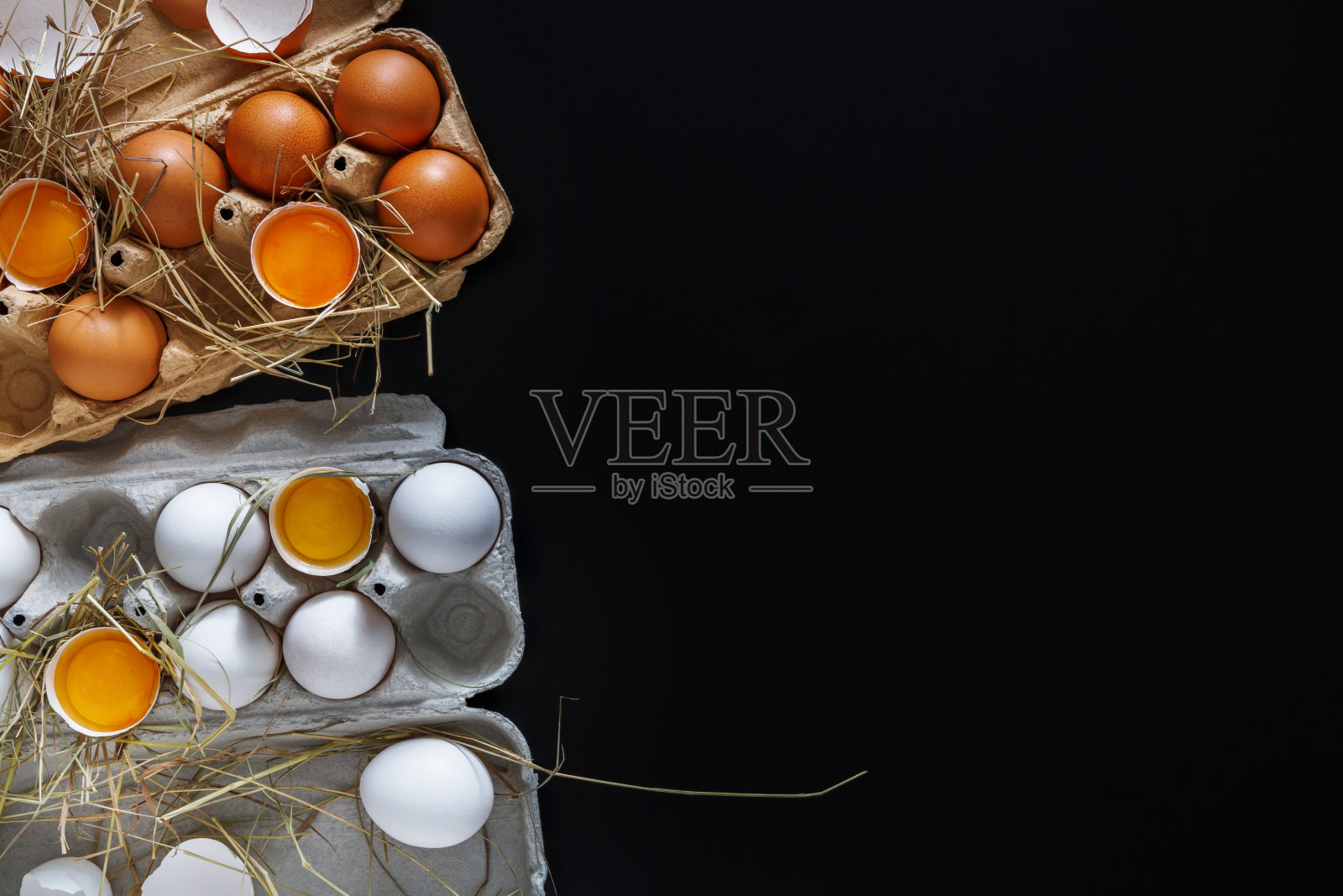 新鲜的白色和棕色的鸡蛋在黑色的背景纸盒照片摄影图片