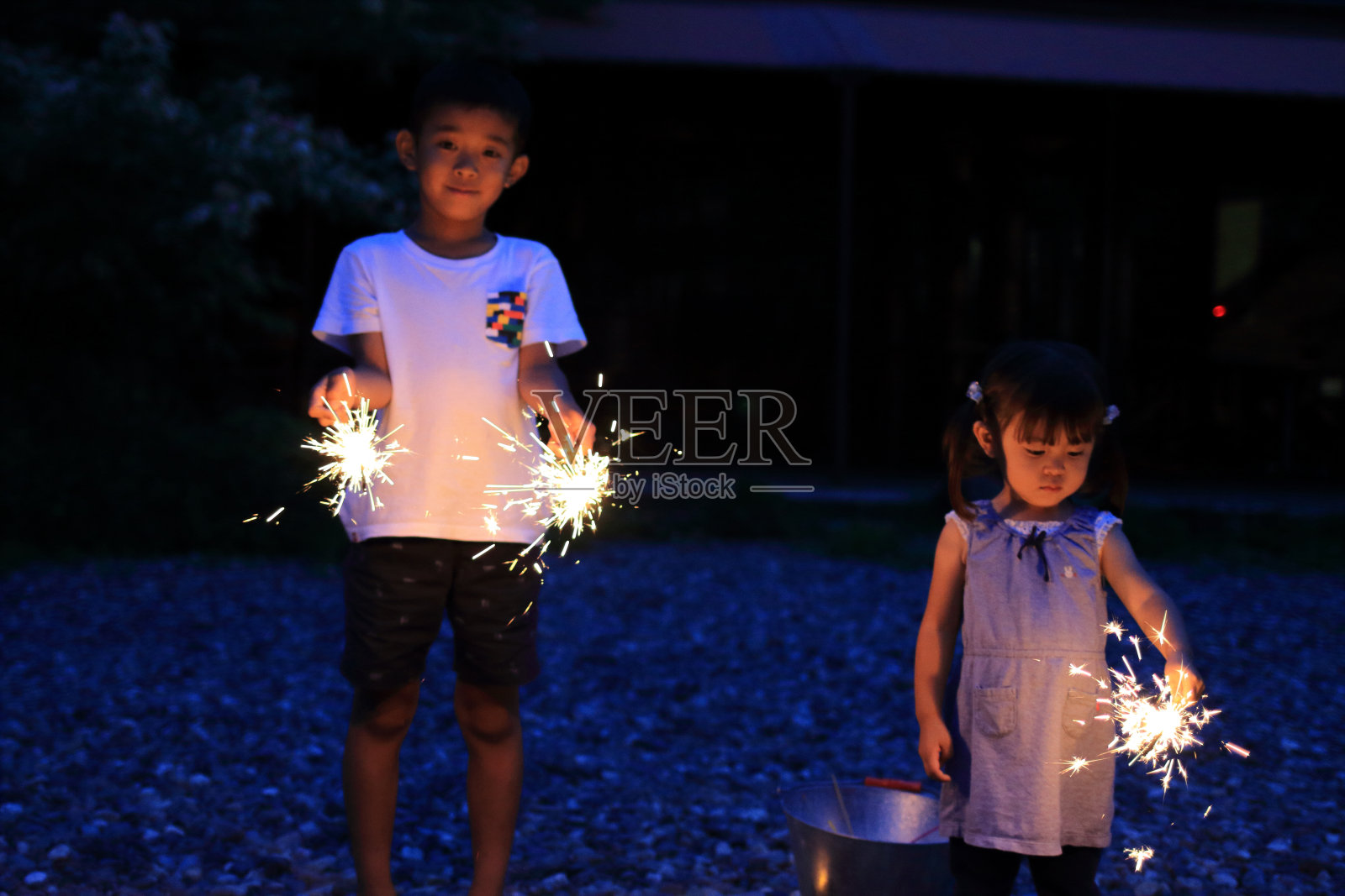 日本兄妹在做手持式烟花(7岁男孩和2岁女孩)照片摄影图片