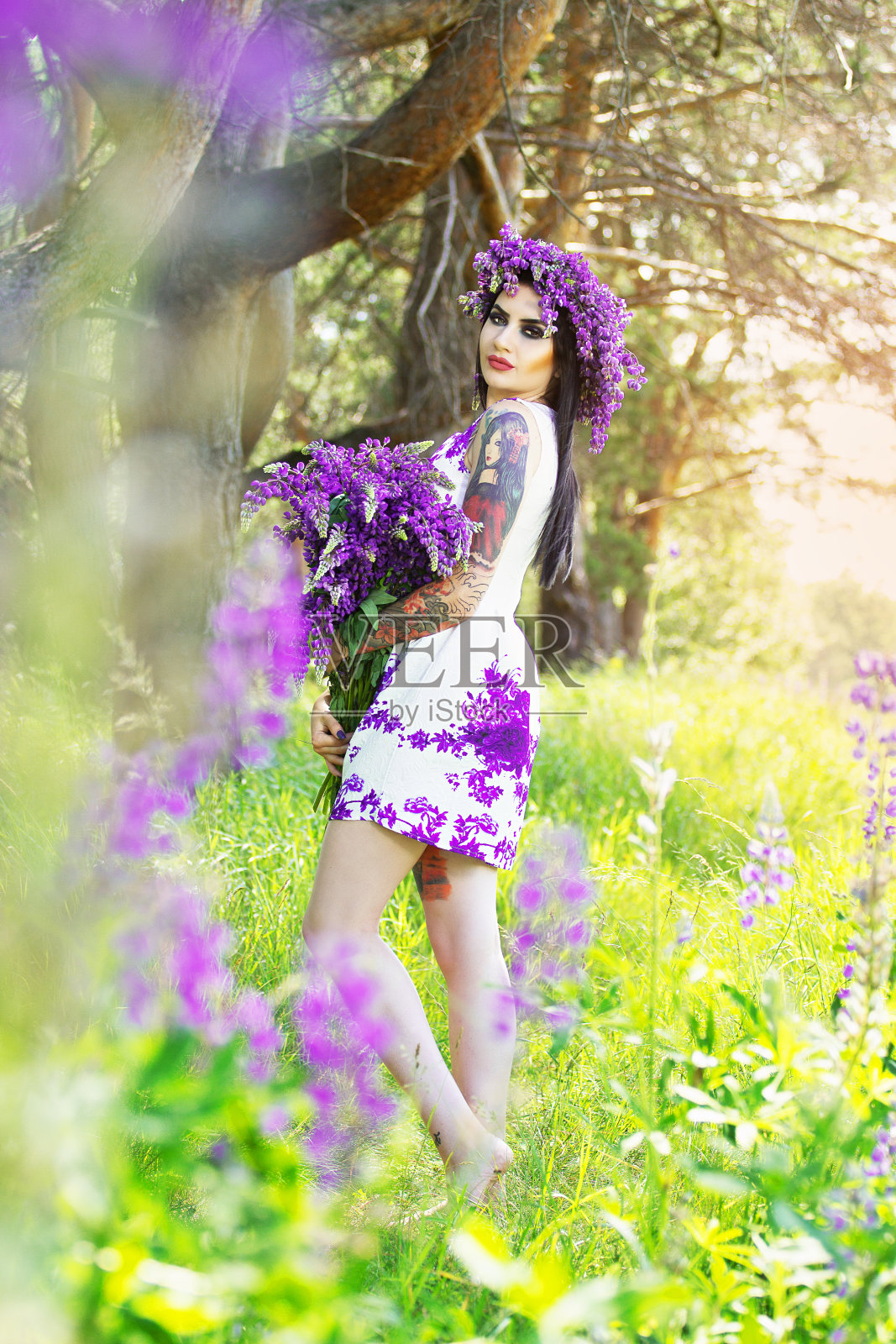 奇怪的纹身女人摆着花的姿势。照片摄影图片