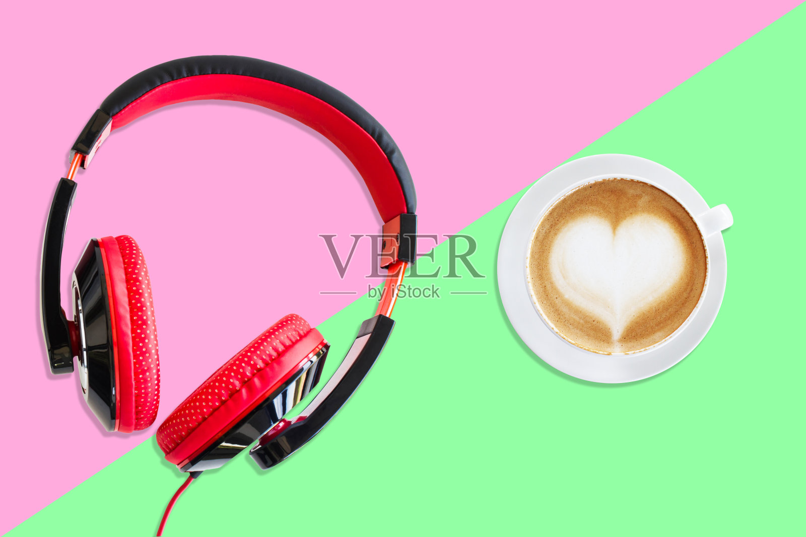 红色和黑色耳机与白色杯热咖啡从顶视图粉红色和绿色的背景。柔和的风格。照片摄影图片
