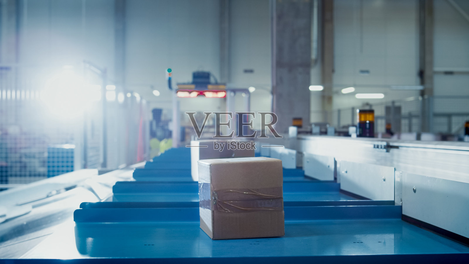 包裹在邮局分拣办公室的传送带上移动。箱子POV。照片摄影图片