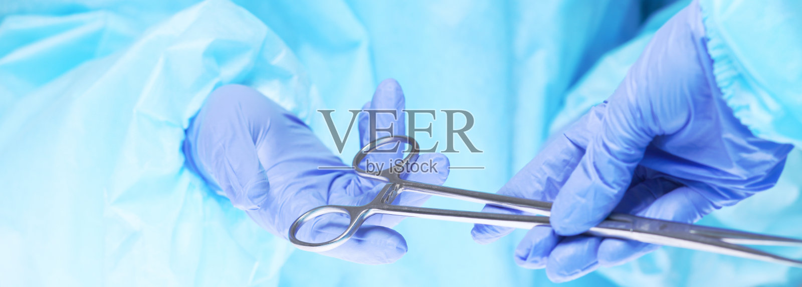 外科医生的双手在手术室工作的特写，色调为蓝色照片摄影图片