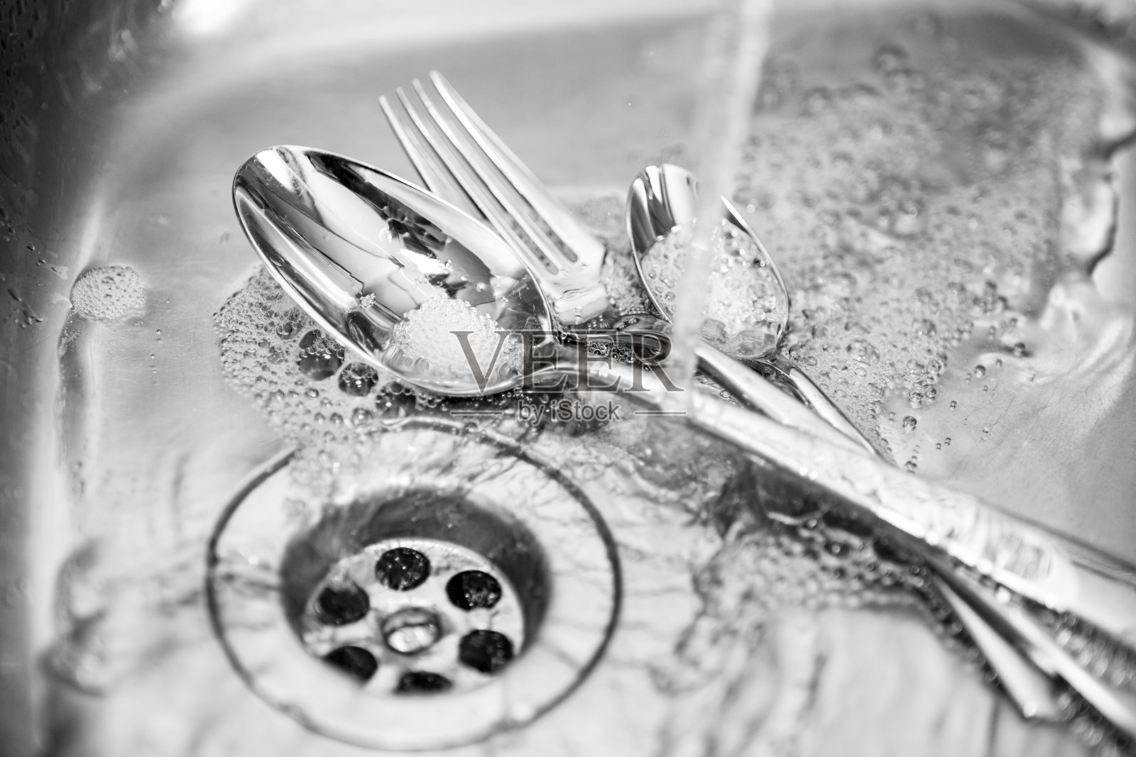 餐具放在厨房水槽里的自来水下照片摄影图片