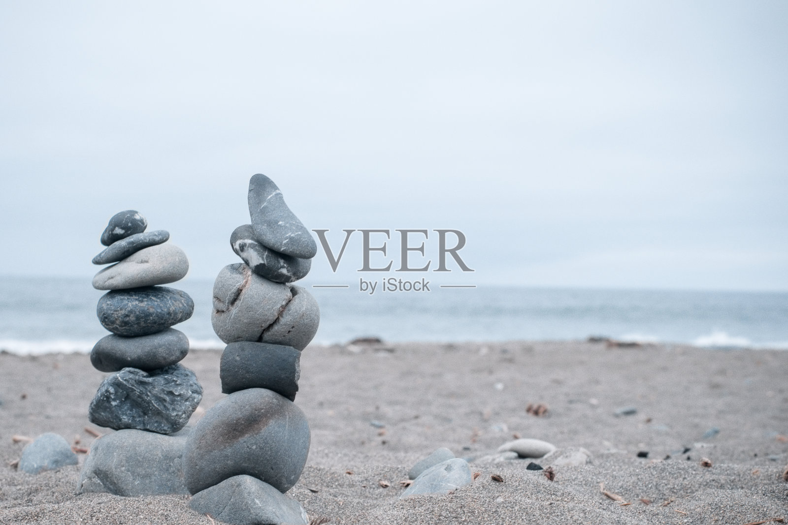 单色，宁静，蓝色堆叠在加利福尼亚海滩上的岩石象征着和平，平衡，冥想，和正念与复制的空间照片摄影图片