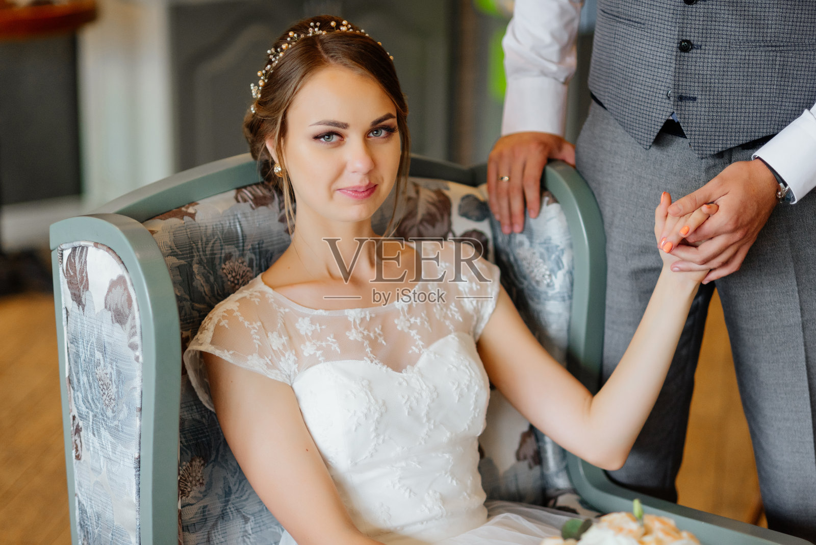 结婚的那一天。室内穿着白色婚纱的美丽年轻新娘。豪华模特坐在长椅上，内饰有新娘花束。的婚礼。照片摄影图片